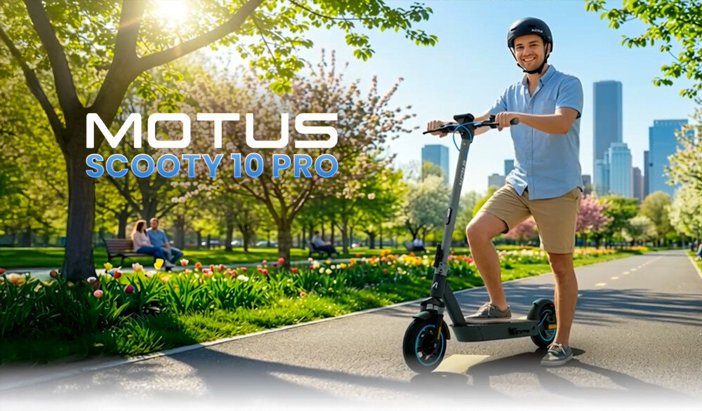 Osoba stoi na elektrycznej hulajnodze na ścieżce w parku, otoczona drzewami i kwiatami. Widoczny jest napis \'MOTUS SCOOTY 10 PRO\'.