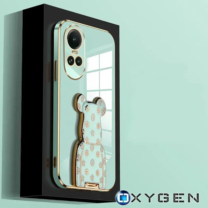 Obraz przedstawia etui na telefon z motywem misia, z trzema dużymi otworami na aparaty. W prawym dolnym rogu widoczne jest logo \'OXYGEN\'.