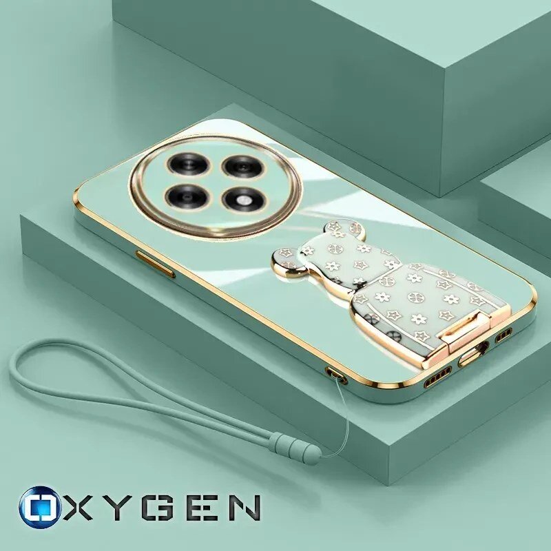 Etui na telefon w kolorze miętowym z ozdobnym uchwytem w kształcie misia i trzema widocznymi obiektywami aparatu. Na dole widoczny jest napis \'OXYGEN\'.