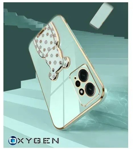 Etui na telefon z lustrzaną powierzchnią i ozdobnym uchwytem w kształcie misia. Widoczne logo: OXYGEN.