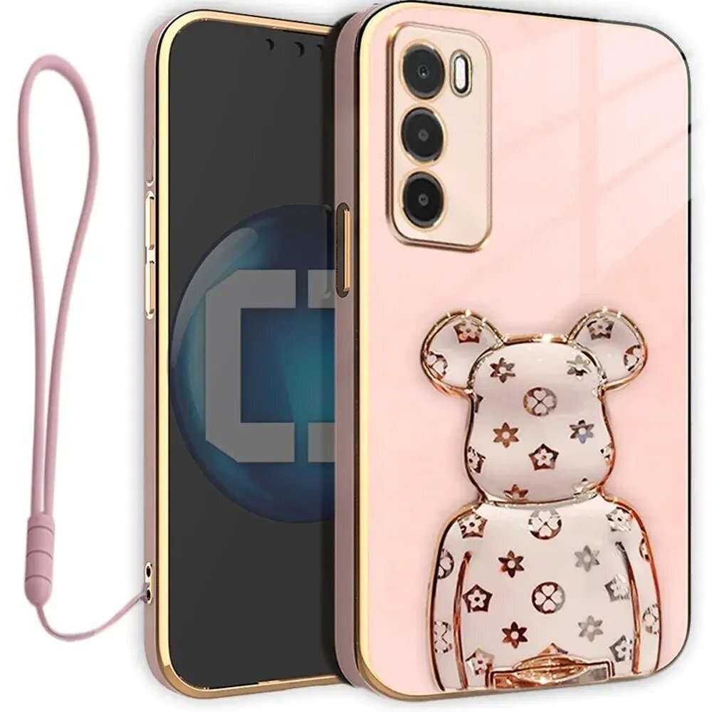 Etui na telefon w kolorze różowym z ozdobnym uchwytem w kształcie misia z wzorami. Obok znajduje się różowa smycz do telefonu.