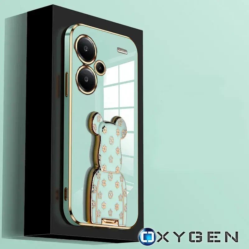 Etui na telefon z trzema widocznymi obiektywami aparatu i ozdobnym uchwytem w kształcie misia. Na dole obrazu znajduje się logo \'OXYGEN\'.