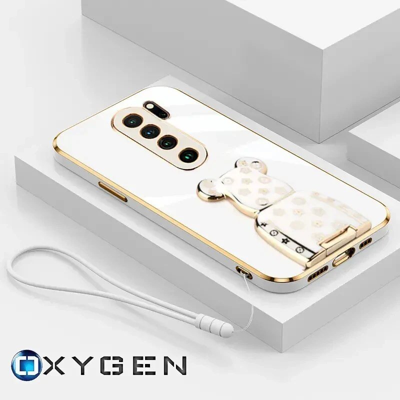 Na obrazie widoczne jest eleganckie etui na telefon z metalicznymi akcentami i uchwytem w kształcie misia. W dolnym rogu znajduje się logo \'OXYGEN\'.