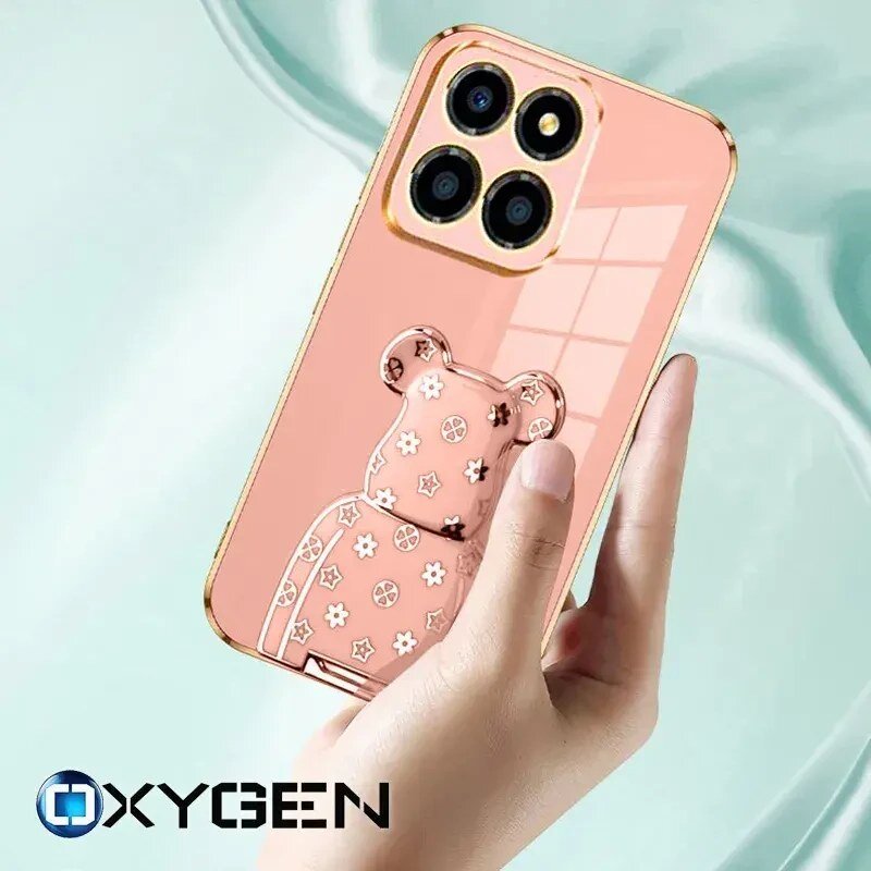 Etui na telefon w kolorze różowym z ozdobnym wzorem misia i wycięciem na aparat z trzema obiektywami. Widoczne logo: OXYGEN.