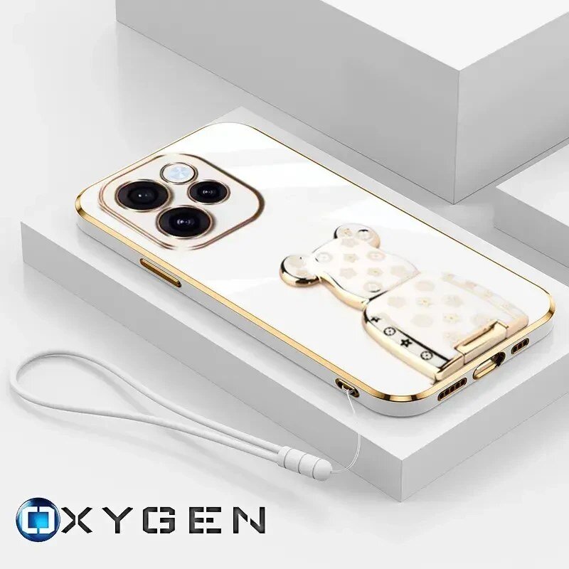 Na obrazie widoczne jest białe etui na telefon z dwoma dużymi otworami na aparaty oraz uchwytem w kształcie misia. W dolnej części znajduje się logo \'OXYGEN\' oraz biała smycz przymocowana do etui.