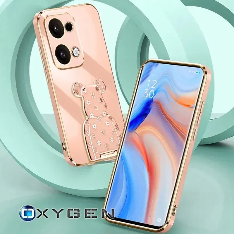 Obraz przedstawia etui na telefon w kolorze różowego złota z uchwytem w kształcie misia, ozdobionym wzorami. Na ekranie telefonu widoczny jest abstrakcyjny wzór oraz godzina 12:30, a w lewym dolnym rogu znajduje się logo OXYGEN.