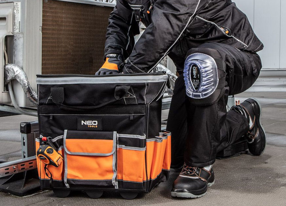 Torba monterska na kołach NEO TOOLS 84-302 wykonana z poliestru 600 D, trwała i solidna konstrukcja - osoba wyjmująca narzędzia z torby