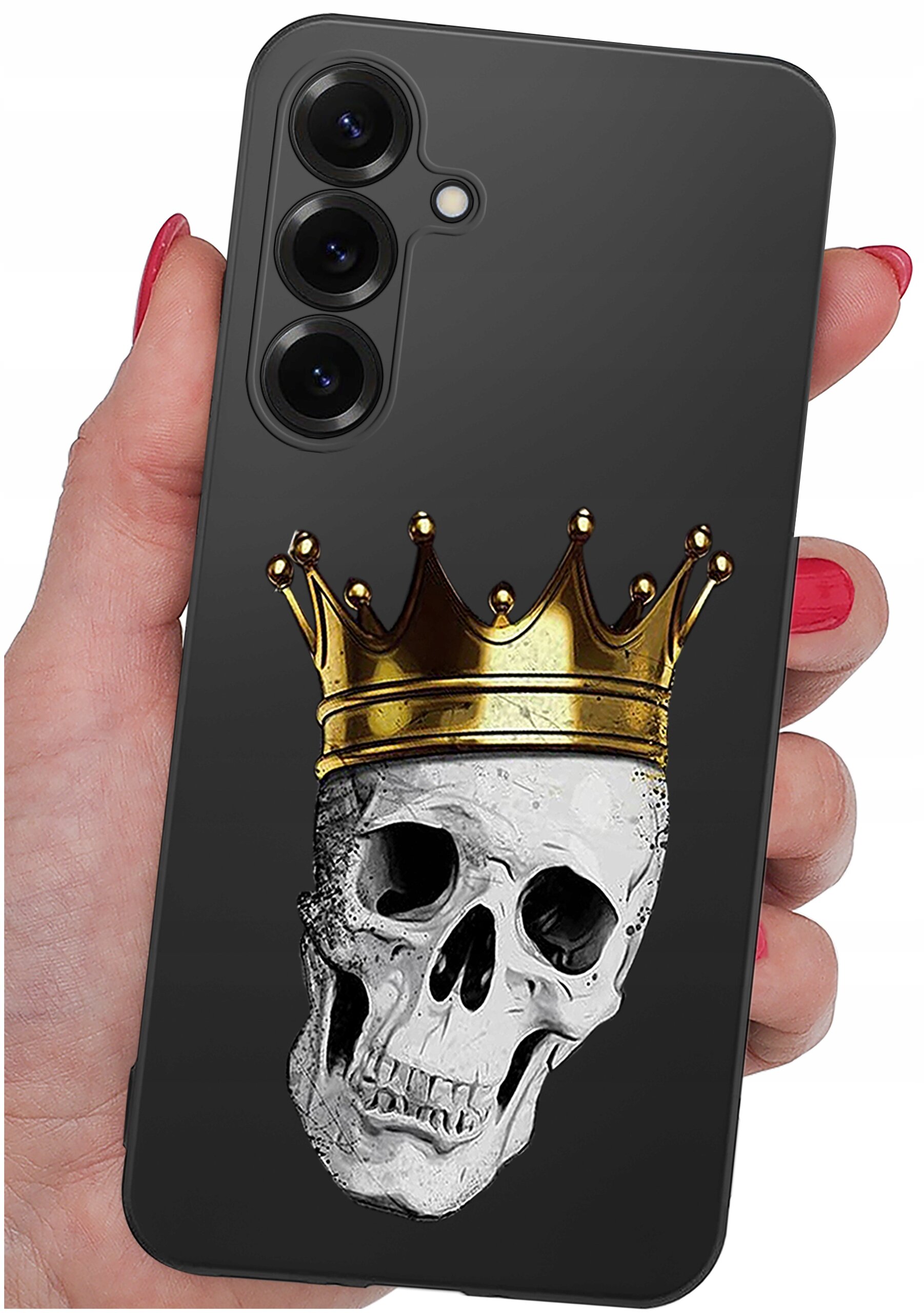Czarne etui na telefon z nadrukiem czaszki w złotej koronie. Etui trzymane jest w dłoni z pomalowanymi na czerwono paznokciami.