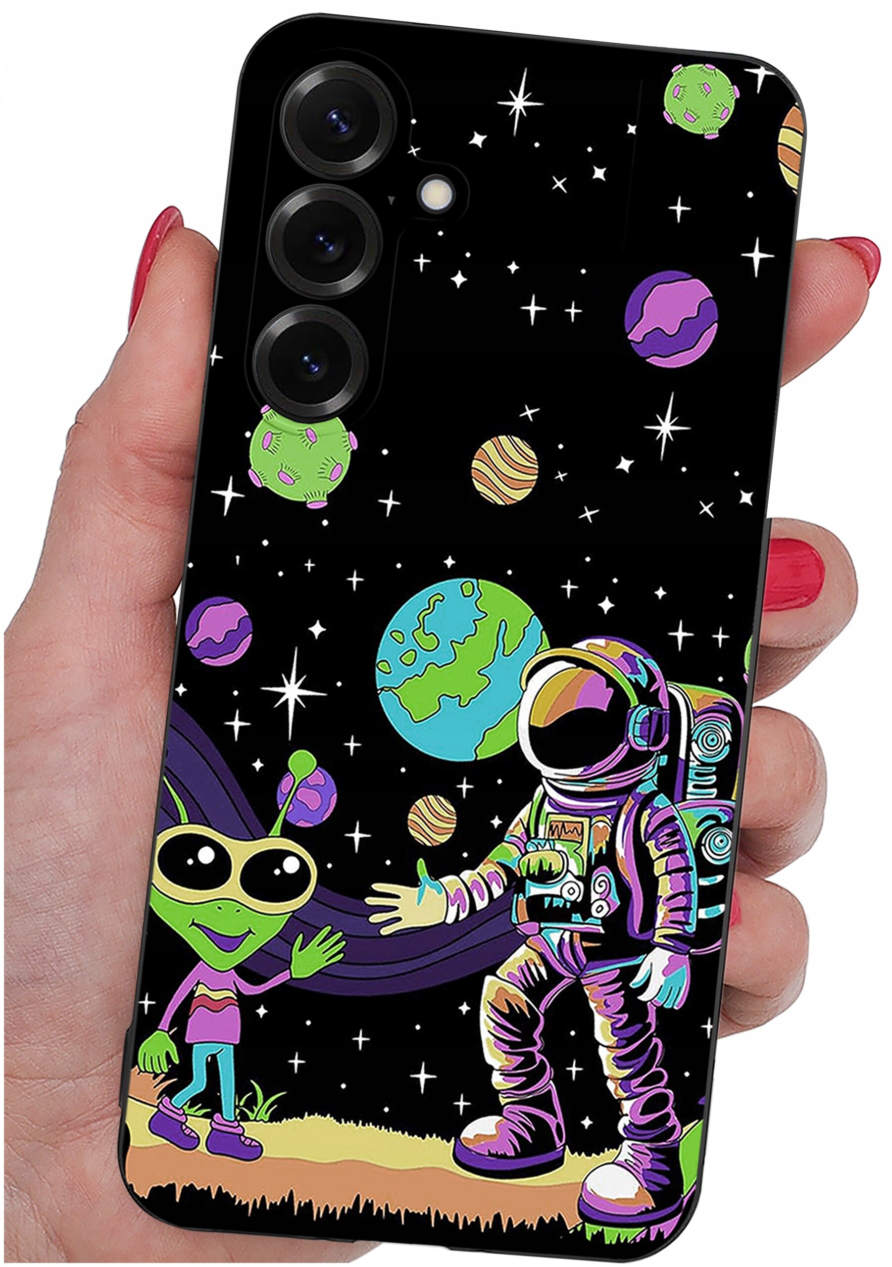 Etui na telefon z kolorowym wzorem przedstawiającym astronautę i zielonego kosmitę na tle kosmosu z planetami i gwiazdami. Etui jest trzymane w dłoni z pomalowanymi na czerwono paznokciami.