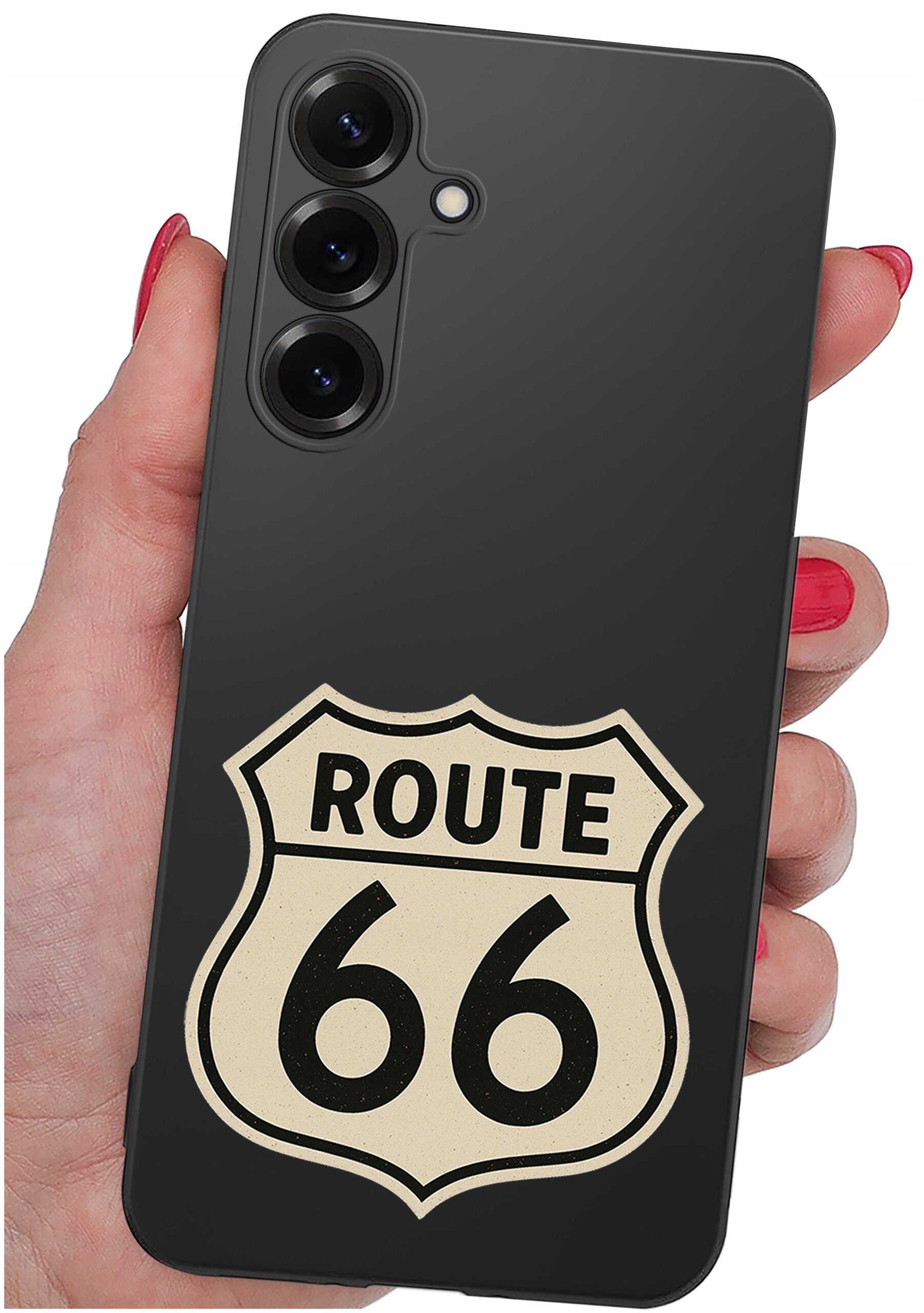 Czarna obudowa telefonu z trzema aparatami i napisem \'ROUTE 66\' na tylnej części. Obudowa jest trzymana w dłoni z pomalowanymi na czerwono paznokciami.