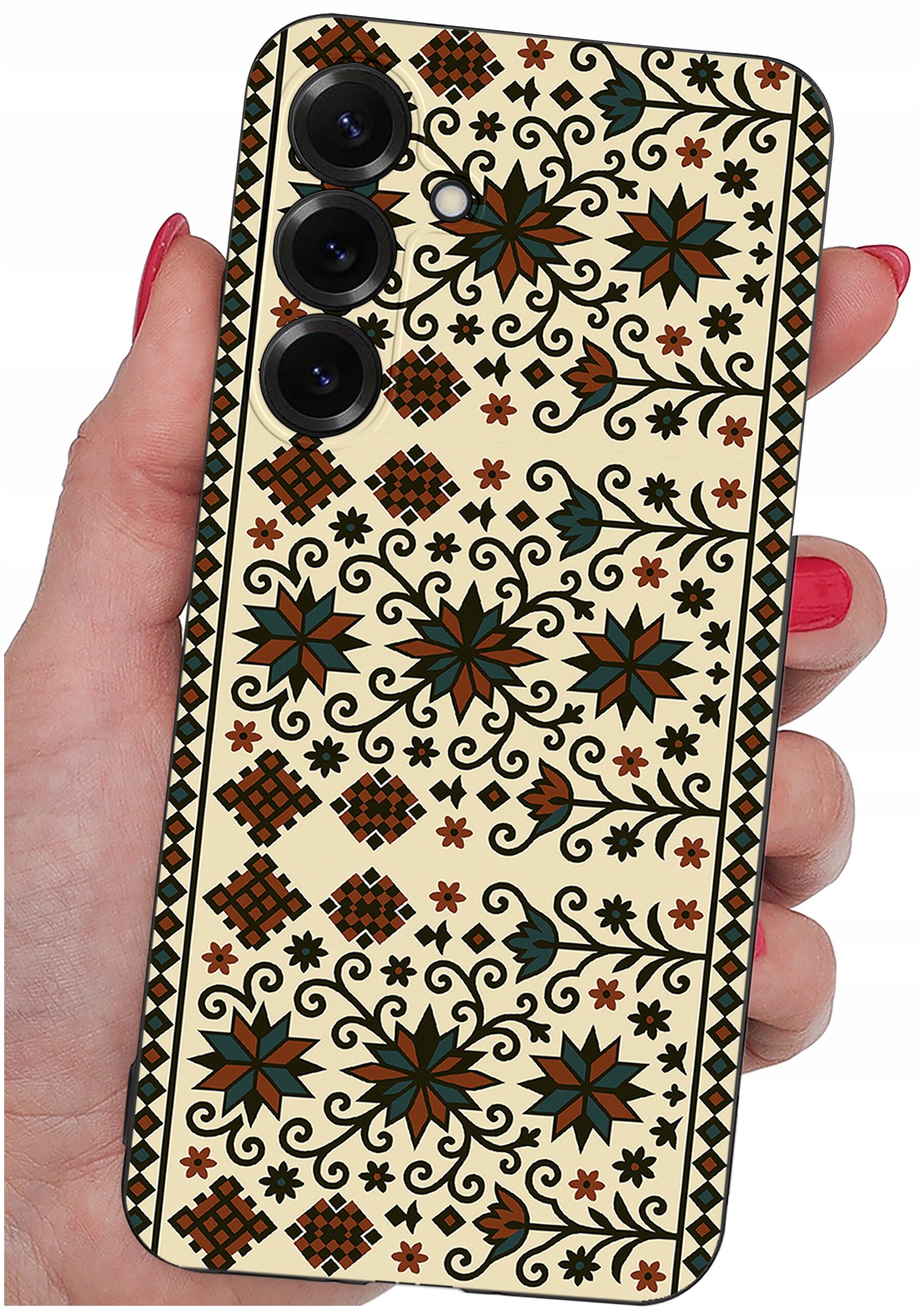 Etui na telefon z wzorem w stylu folkowym, przedstawiającym kwiaty i geometryczne kształty w kolorach brązu, zieleni i czerni. Etui trzymane jest w dłoni z pomalowanymi na czerwono paznokciami.