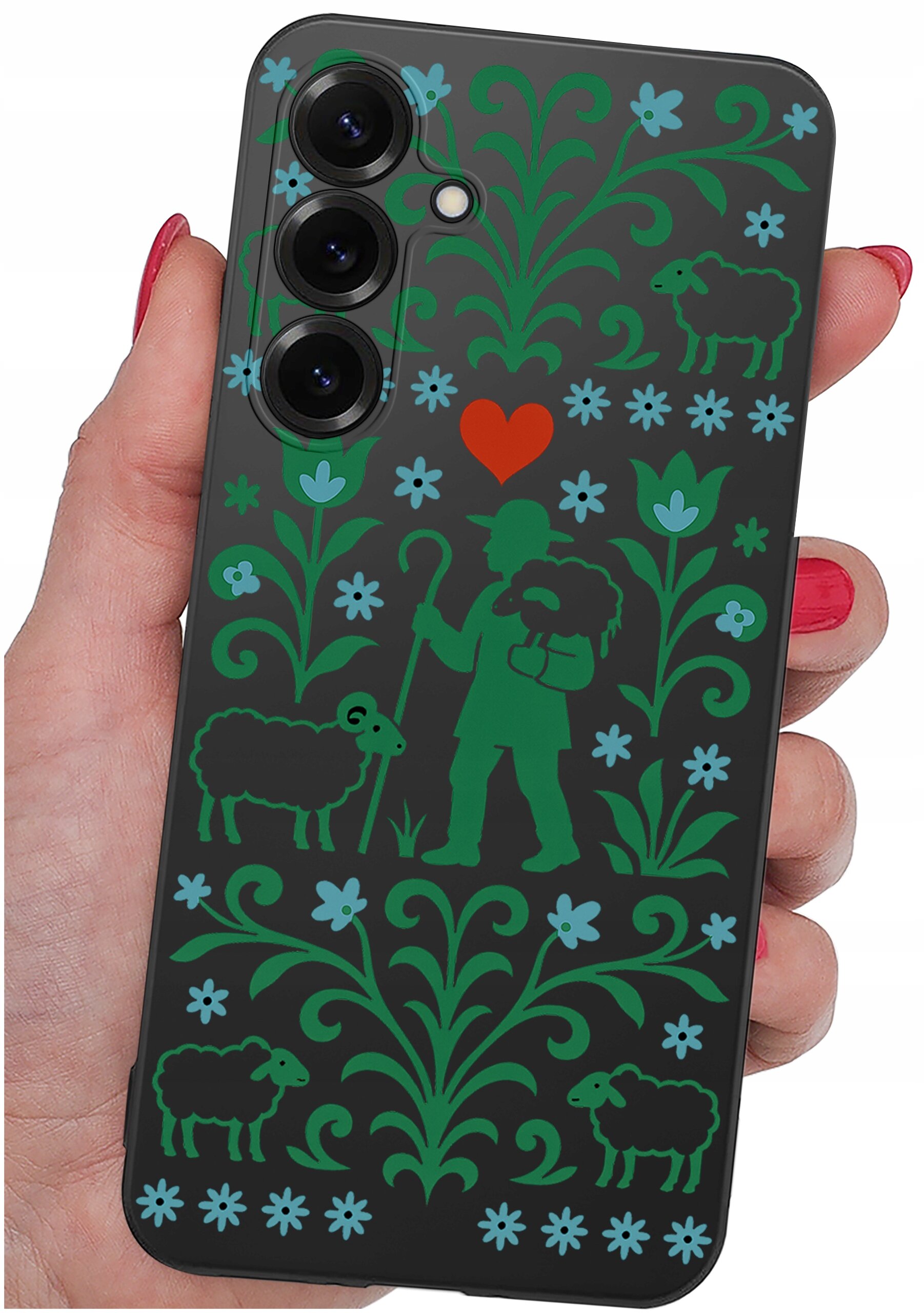 Etui na telefon z wzorem przedstawiającym pasterza z owcami, otoczonego kwiatowymi motywami w kolorach zielonym i niebieskim, z czerwonym sercem na środku. Etui trzymane jest w dłoni z pomalowanymi na czerwono paznokciami.