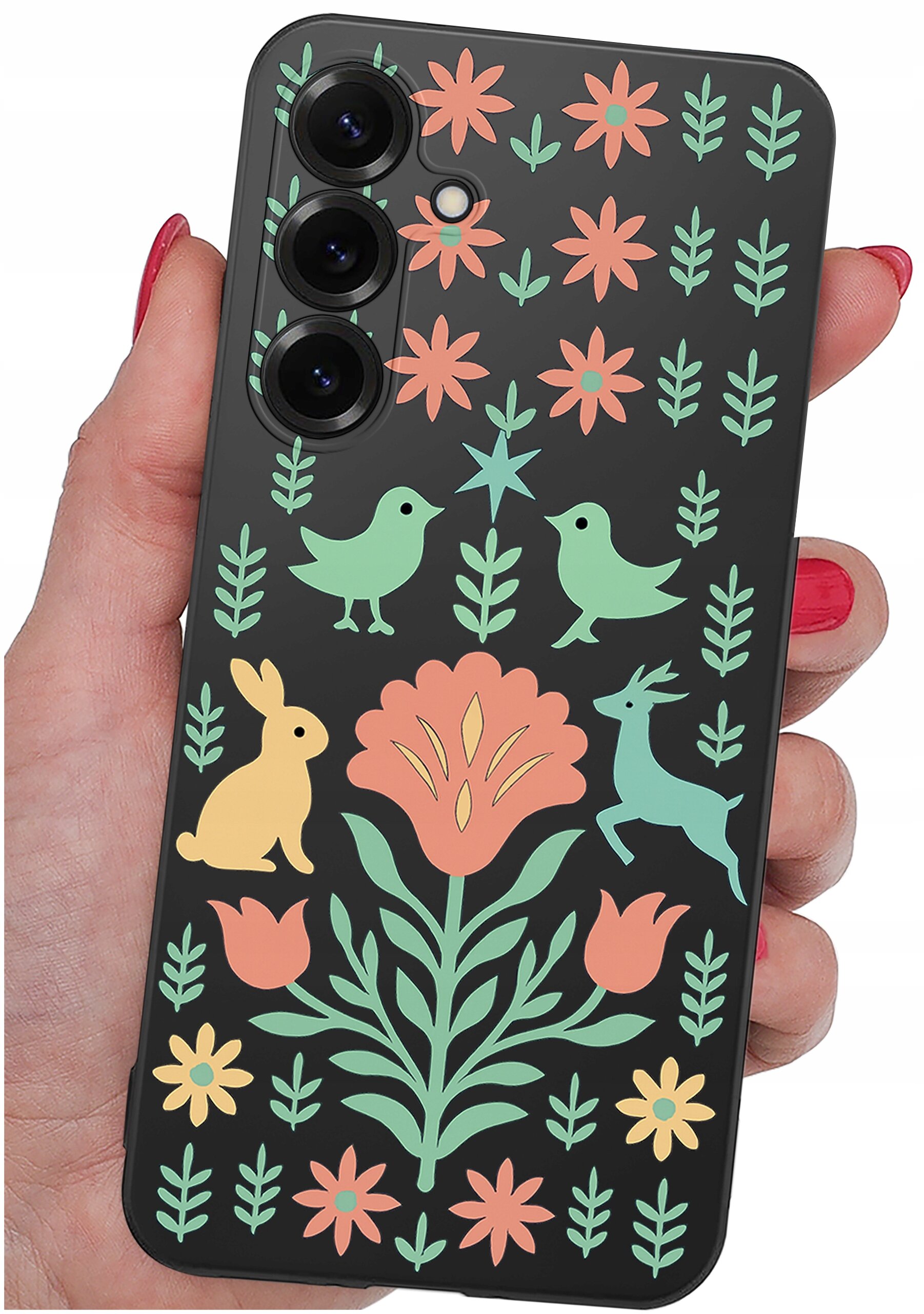 Etui na telefon z kolorowym wzorem przedstawiającym kwiaty, ptaki, królika i jelenia na czarnym tle. Etui trzymane jest w dłoni z pomalowanymi na czerwono paznokciami.