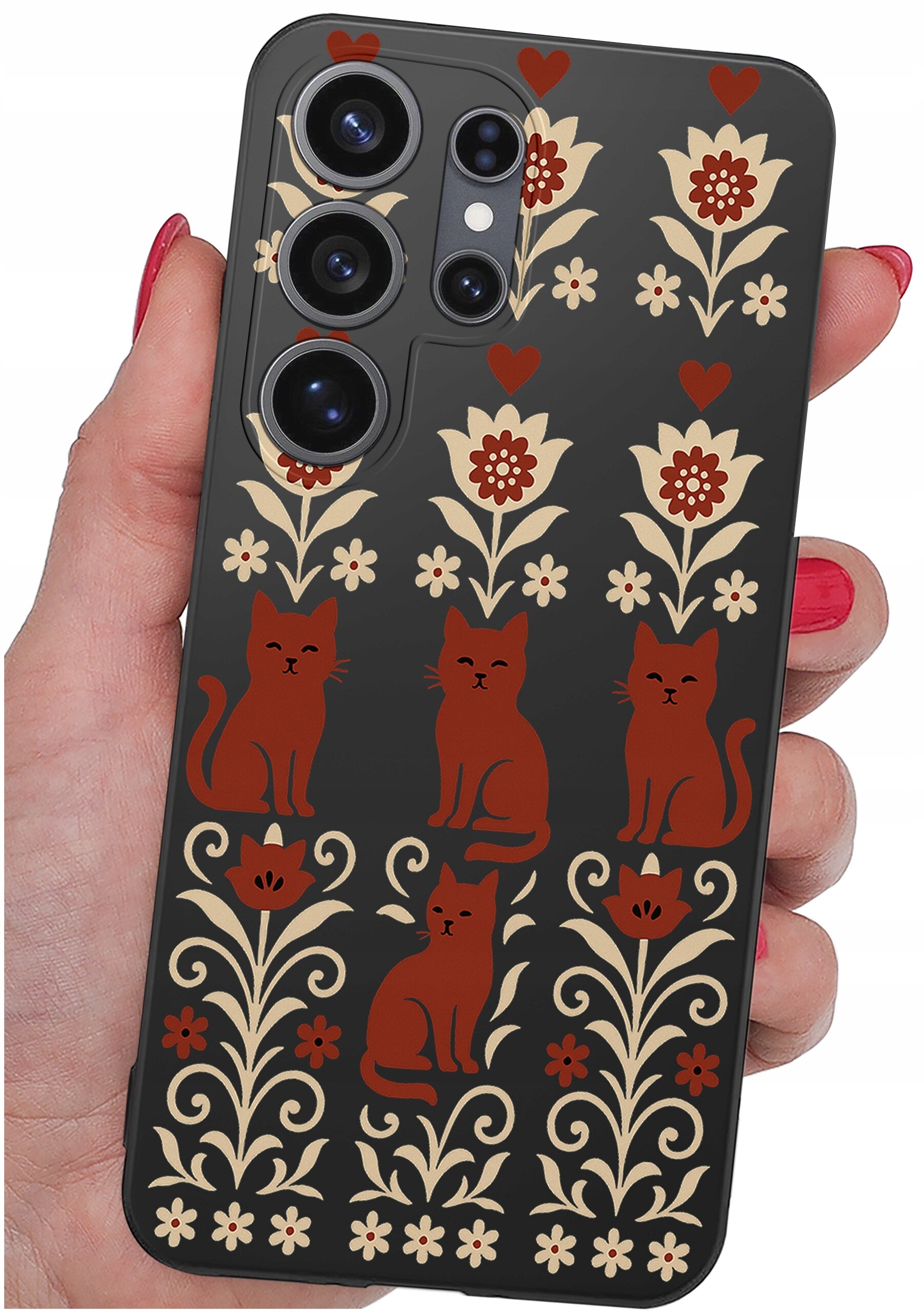Etui na telefon z motywem czerwonych kotów i kwiatów na ciemnym tle, trzymane w dłoni z czerwonym lakierem na paznokciach.