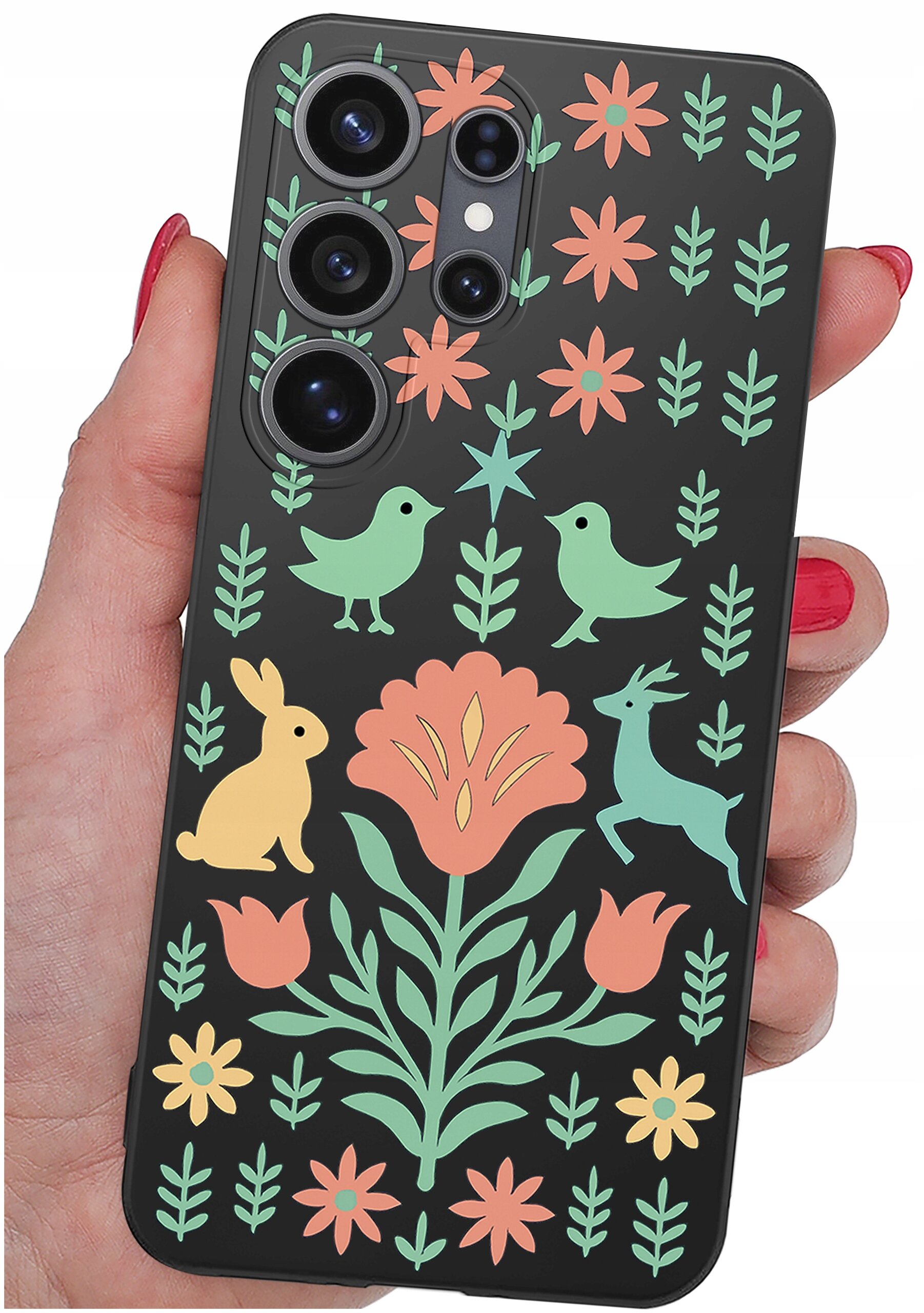Etui na telefon z kolorowym wzorem przedstawiającym kwiaty, ptaki, królika i jelenia na czarnym tle. Etui jest trzymane w dłoni z pomalowanymi na czerwono paznokciami.