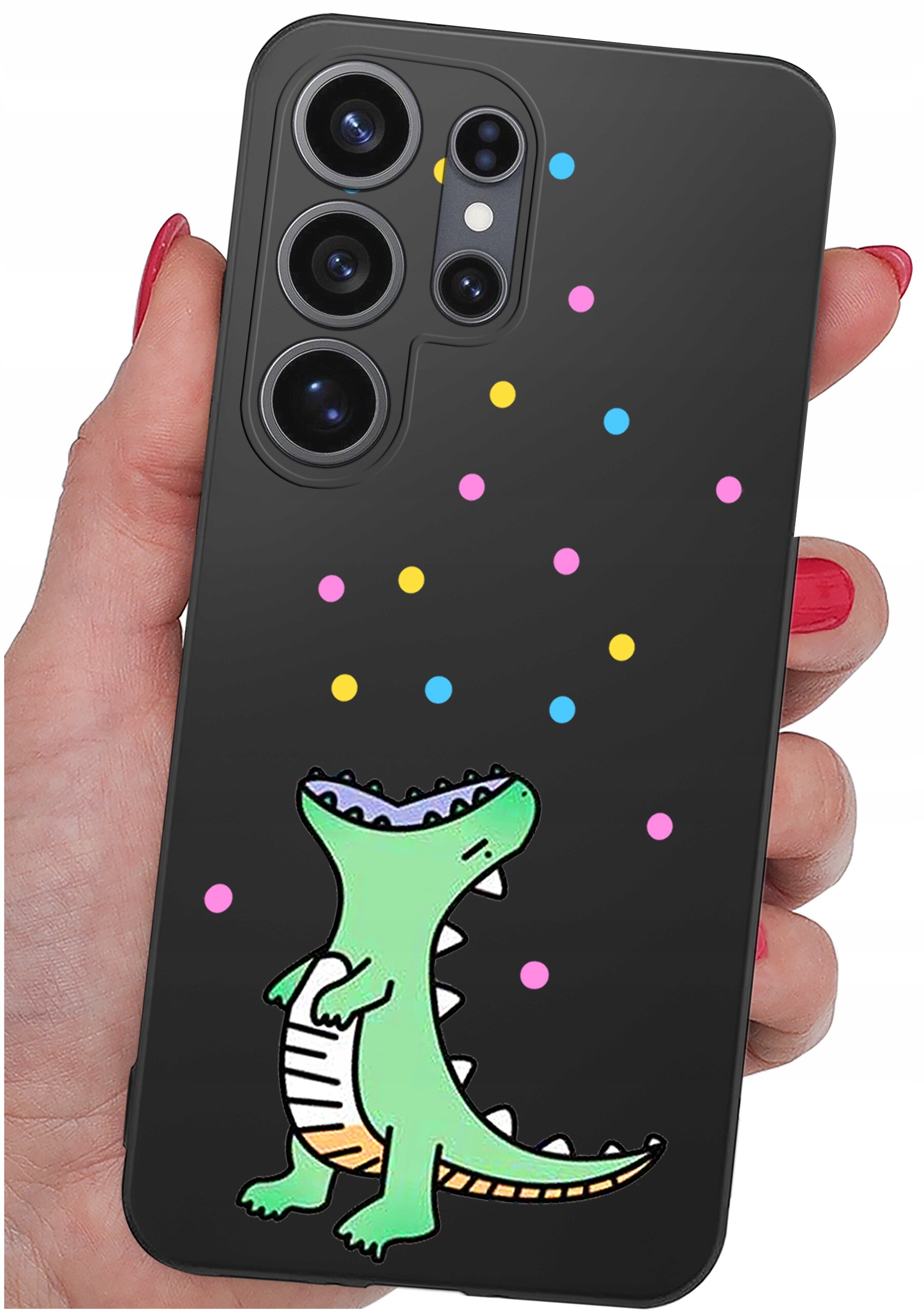 Czarne etui na telefon z kolorowym wzorem przedstawiającym zielonego dinozaura i kolorowe kropki. Etui jest trzymane w dłoni z pomalowanymi na czerwono paznokciami.