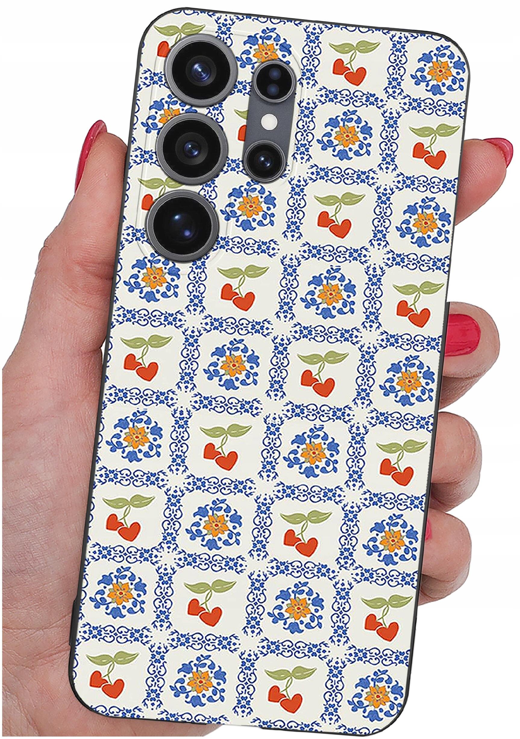 Etui na telefon z wzorem w kwadraty, w których znajdują się motywy kwiatowe i czerwone serca z zielonymi liśćmi. Etui trzymane jest w dłoni z pomalowanymi na czerwono paznokciami.