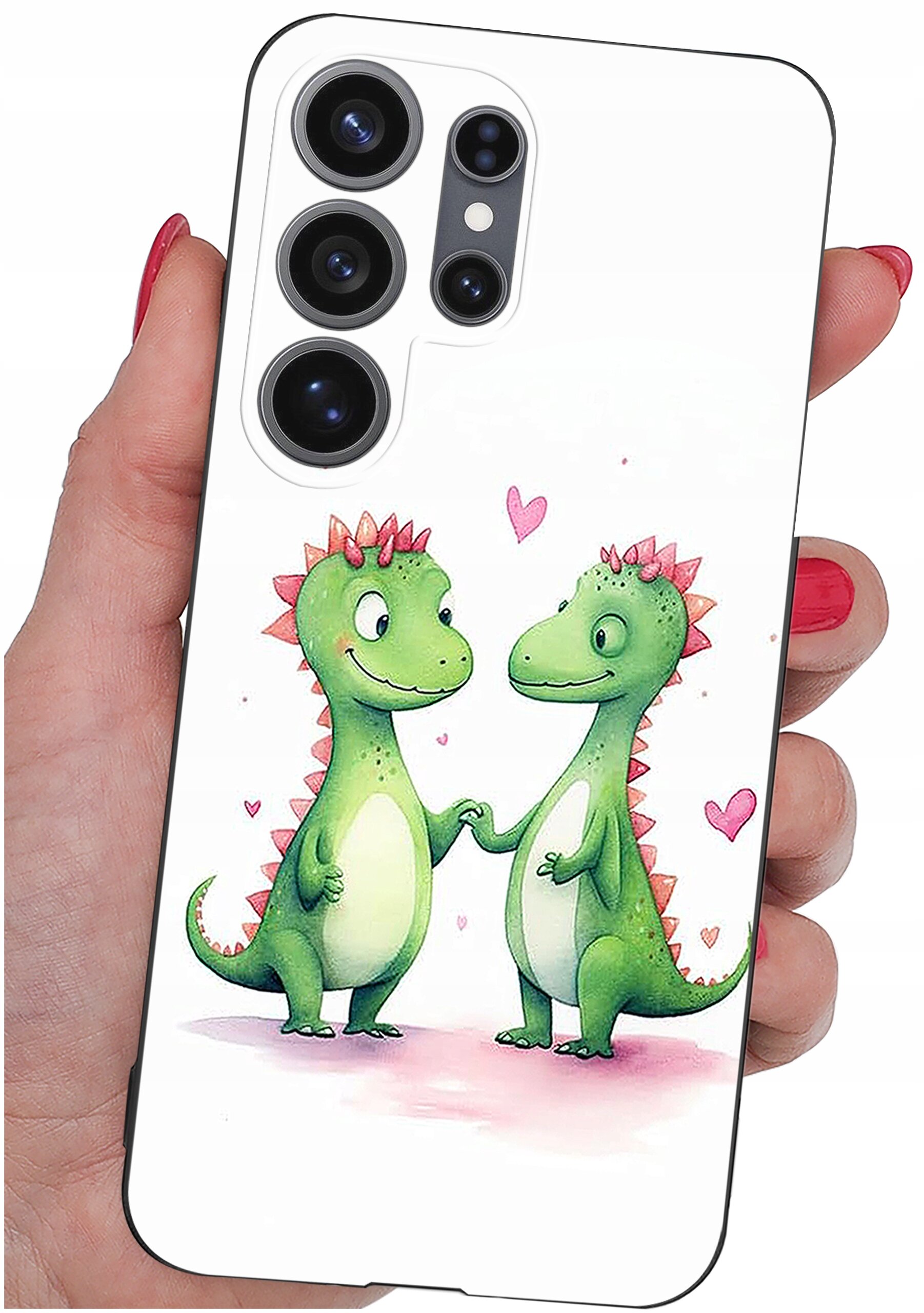 Etui na telefon z nadrukiem dwóch zielonych dinozaurów trzymających się za ręce, otoczonych różowymi serduszkami. Etui jest trzymane w dłoni z pomalowanymi na czerwono paznokciami.
