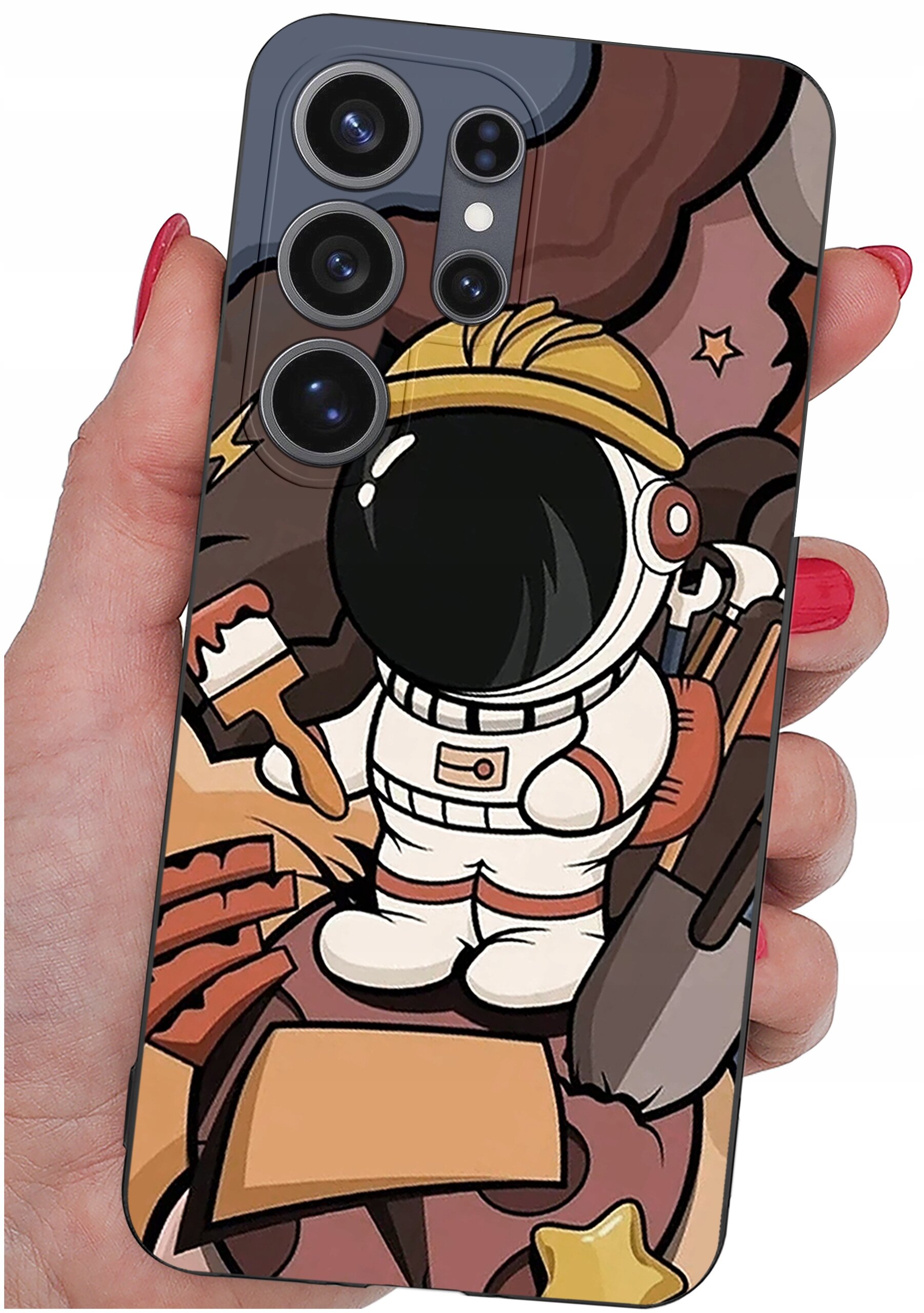 Etui na telefon z kolorowym wzorem przedstawiającym postać astronauty w kasku, trzymającego pędzel i łopatę. Etui jest trzymane w dłoni z pomalowanymi na czerwono paznokciami.