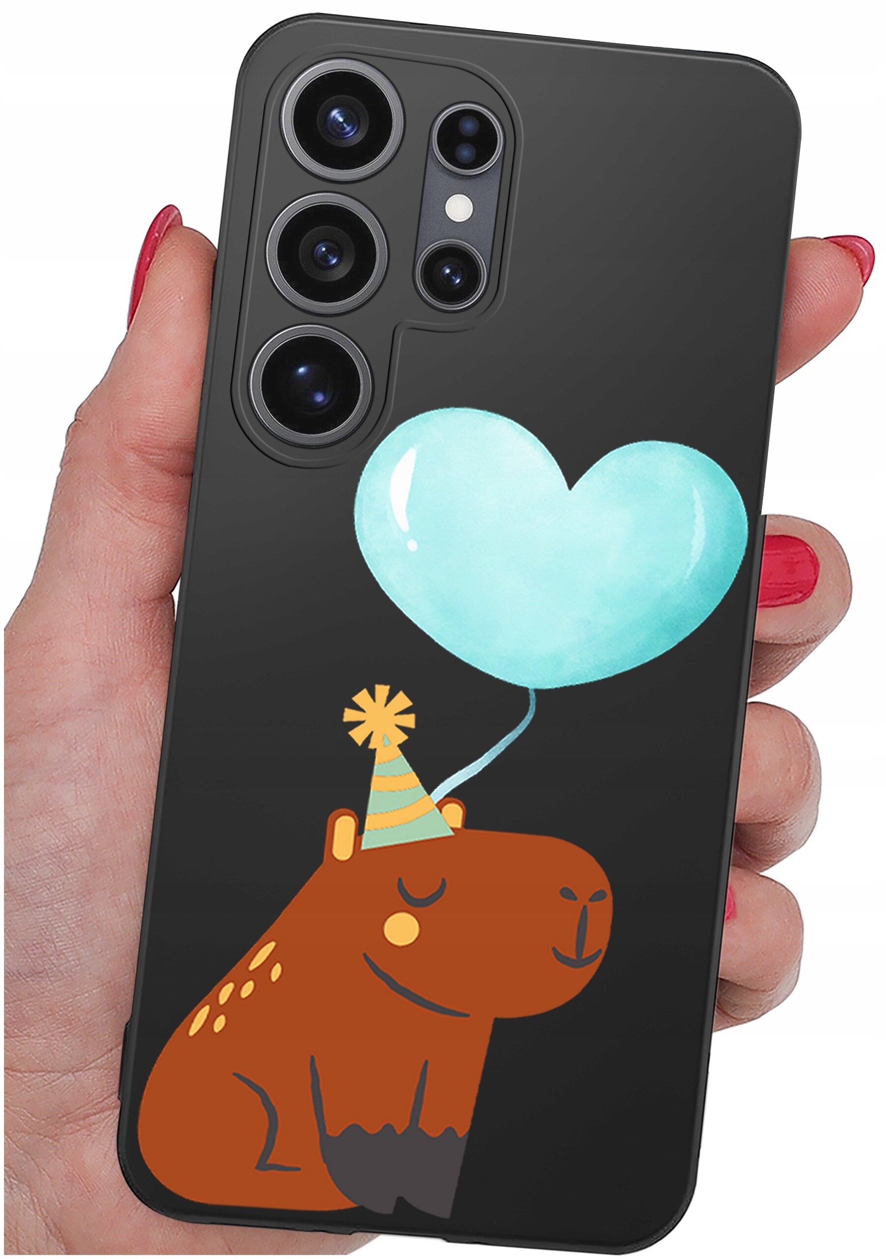 Etui na telefon z czarnym tłem, ozdobione rysunkiem brązowego zwierzęcia w czapce imprezowej oraz niebieskim balonikiem w kształcie serca. Etui trzymane jest w dłoni z pomalowanymi na czerwono paznokciami.