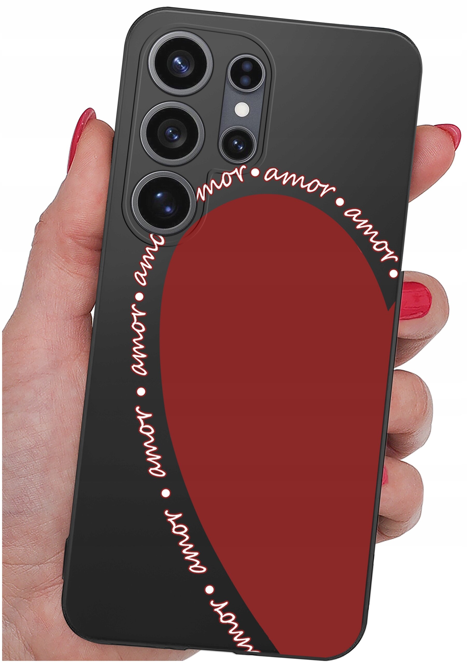 Osoba trzyma telefon z czarnym etui, na którym widoczny jest czerwony kształt serca oraz napis \'amor\' powtarzający się wokół serca.