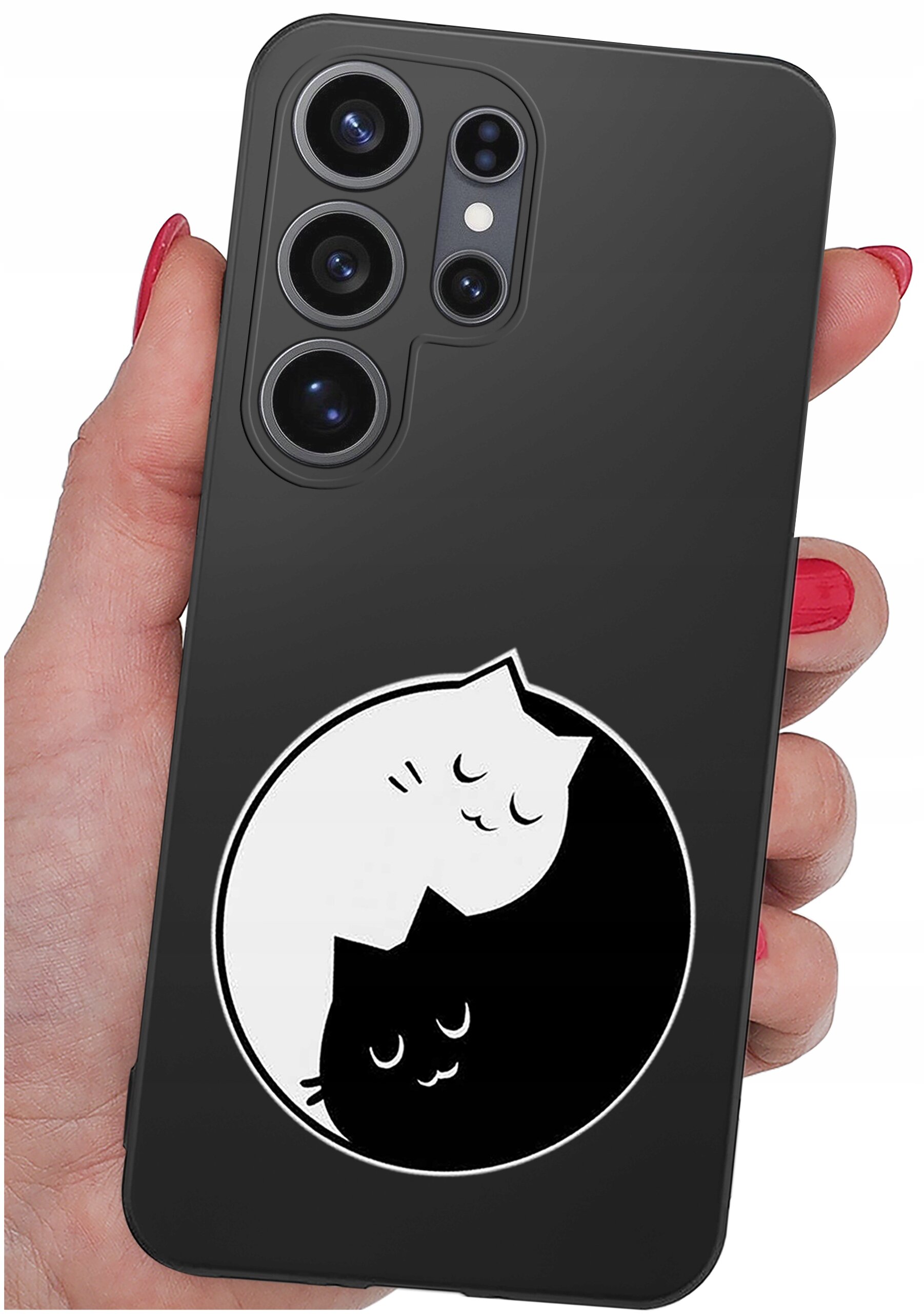 Czarne etui na telefon z motywem dwóch kotów w stylu yin-yang, trzymane w dłoni z pomalowanymi na czerwono paznokciami. Etui posiada wycięcia na cztery obiektywy aparatu.