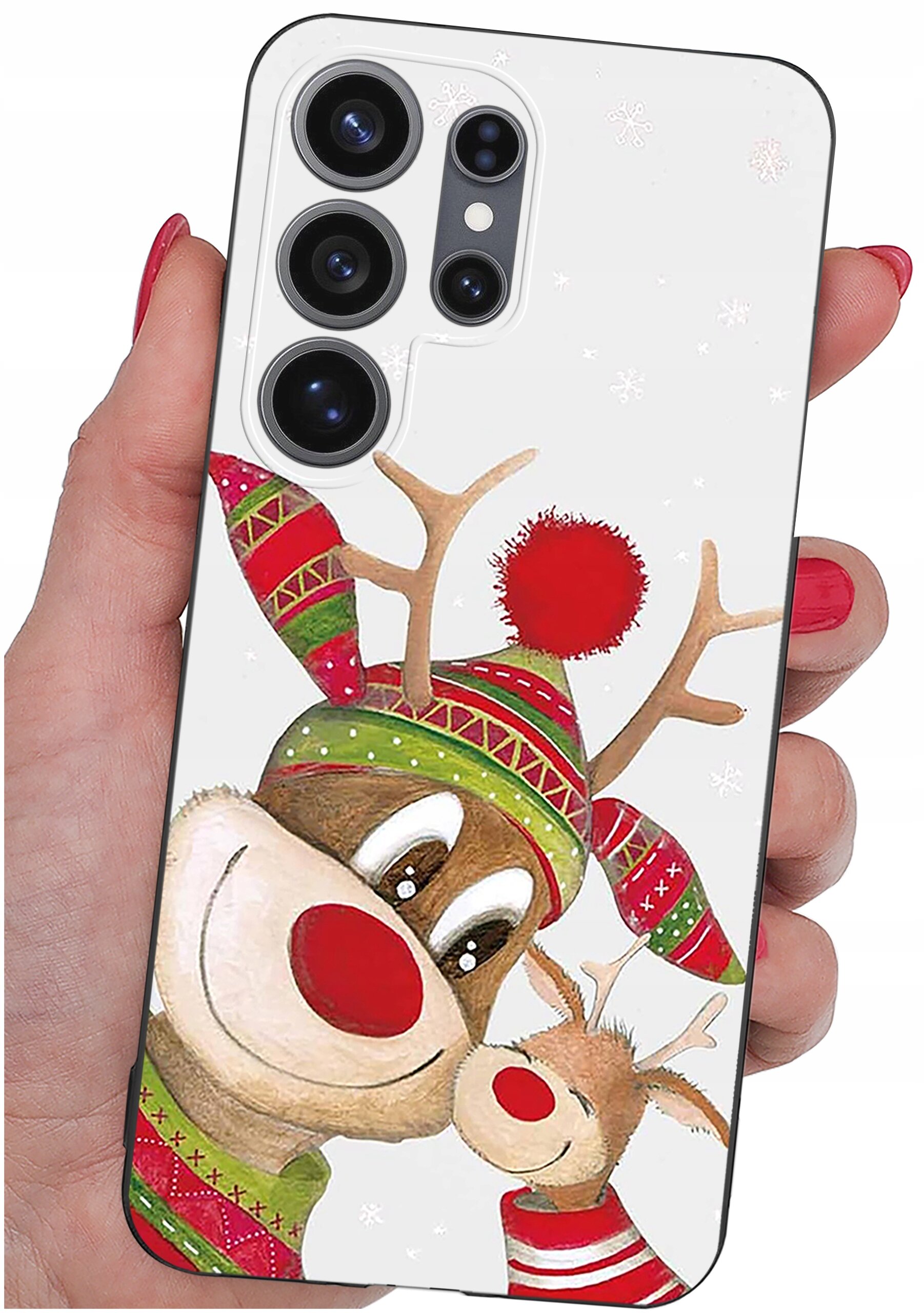 Etui na telefon z motywem renifera w czapce i szaliku w świąteczne wzory, trzymane w dłoni z czerwonym lakierem na paznokciach. Etui ma wycięcia na cztery obiektywy aparatu.