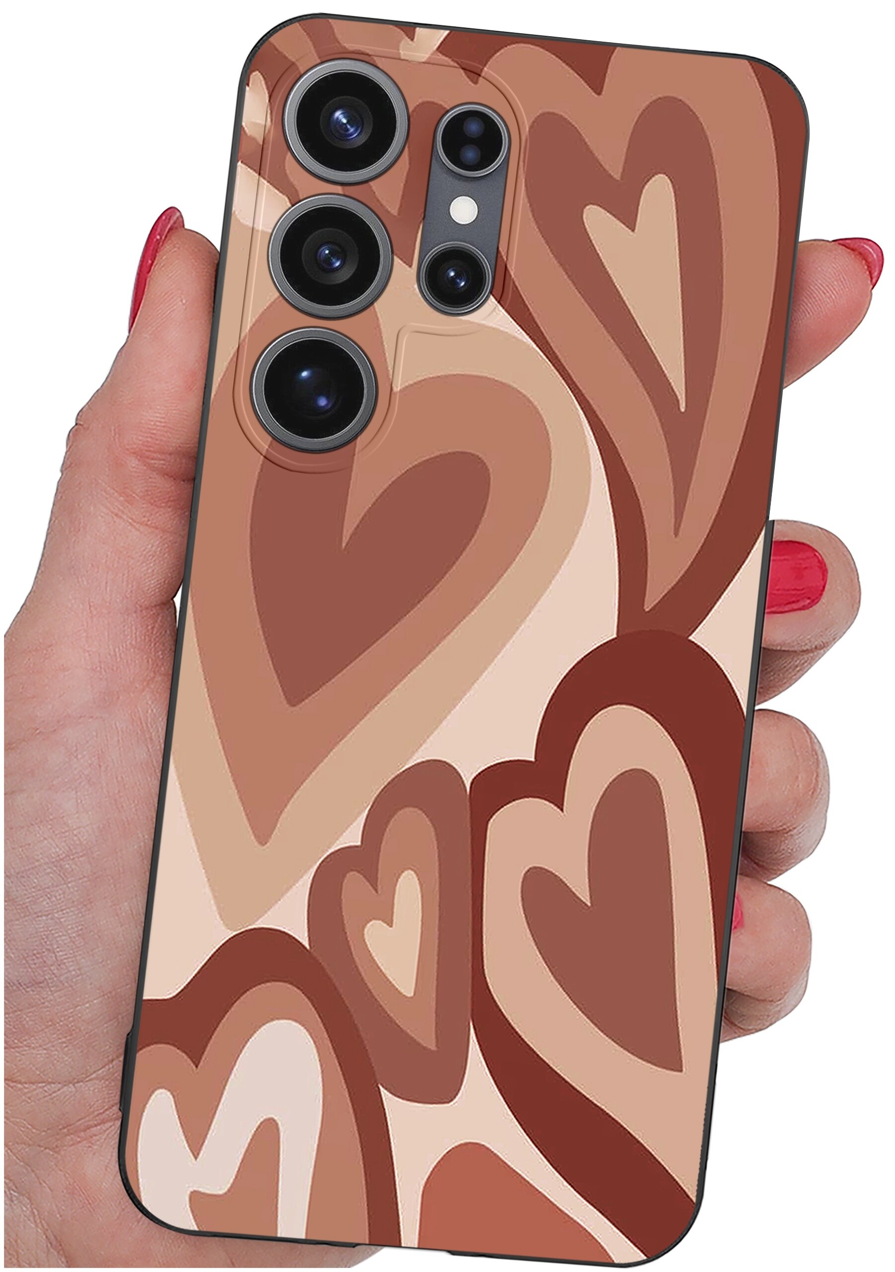 Etui na telefon z wzorem w brązowe serca, trzymane w dłoni z czerwonymi paznokciami. Widoczne są cztery obiektywy aparatu telefonu.