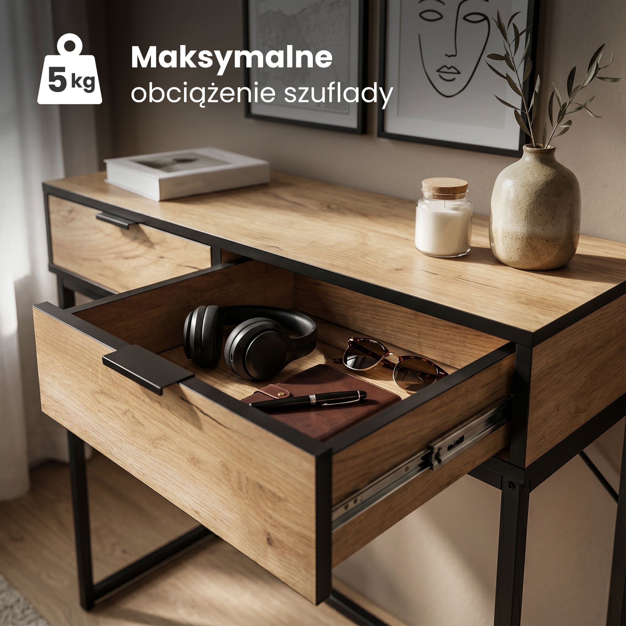 Drewniany stolik z czarnymi metalowymi nogami, z otwartą szufladą, w której znajdują się słuchawki, okulary przeciwsłoneczne i notes. Na blacie stoi wazon z rośliną, świeca i książka, a na ścianie wiszą dwa obrazy; tekst na obrazie: \'Maksymalne obciążenie szuflady 5 kg\'.
