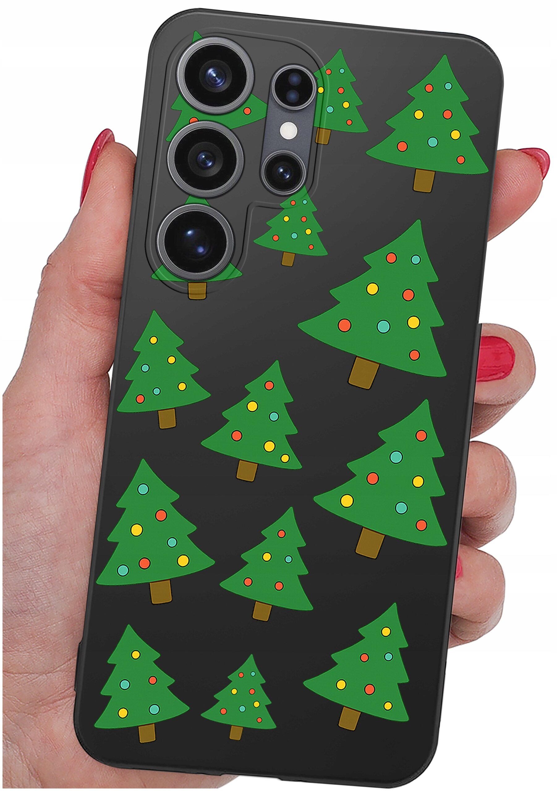 Etui na telefon z czarnym tłem ozdobione wzorem zielonych choinek z kolorowymi bombkami. Etui trzymane jest w dłoni z pomalowanymi na czerwono paznokciami.