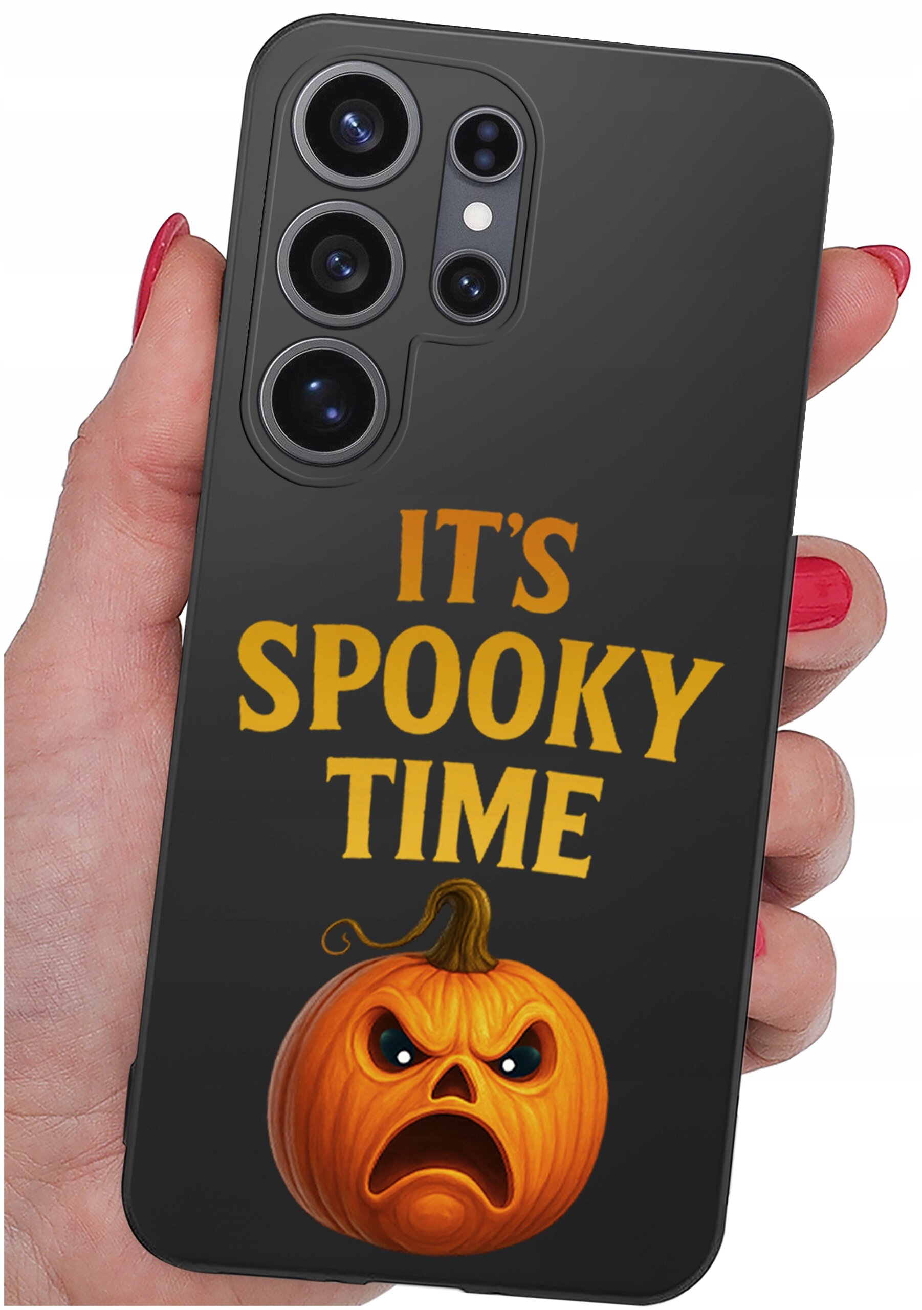 Czarna obudowa telefonu z napisem \'IT\'S SPOOKY TIME\' oraz grafiką pomarańczowej dyni z groźnym wyrazem twarzy. Obudowa jest trzymana w dłoni z czerwonymi paznokciami.