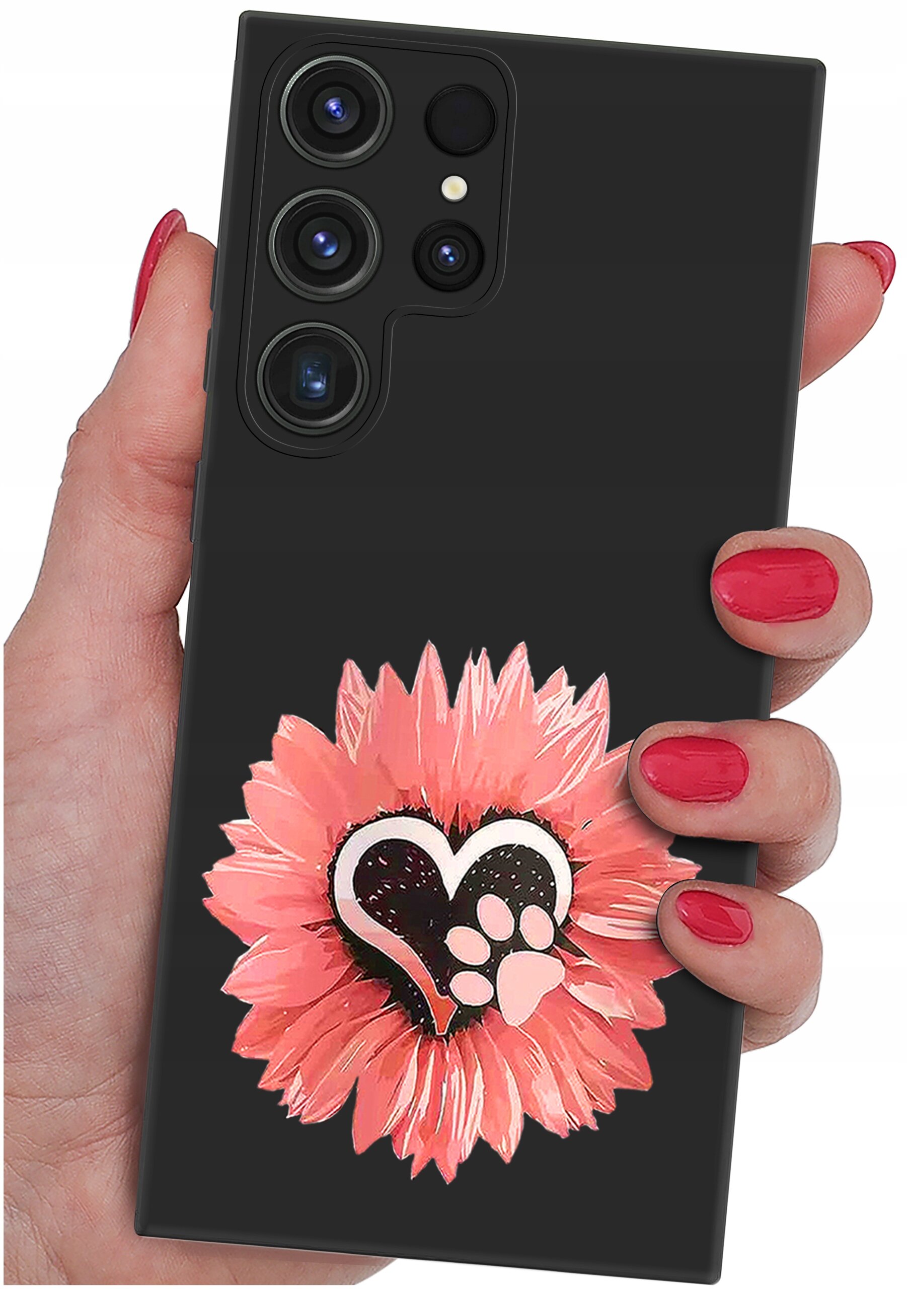 Osoba trzyma telefon z czarnym etui ozdobionym różowym kwiatem i sercem z odciskiem łapy. Etui ma wycięcia na cztery obiektywy aparatu.