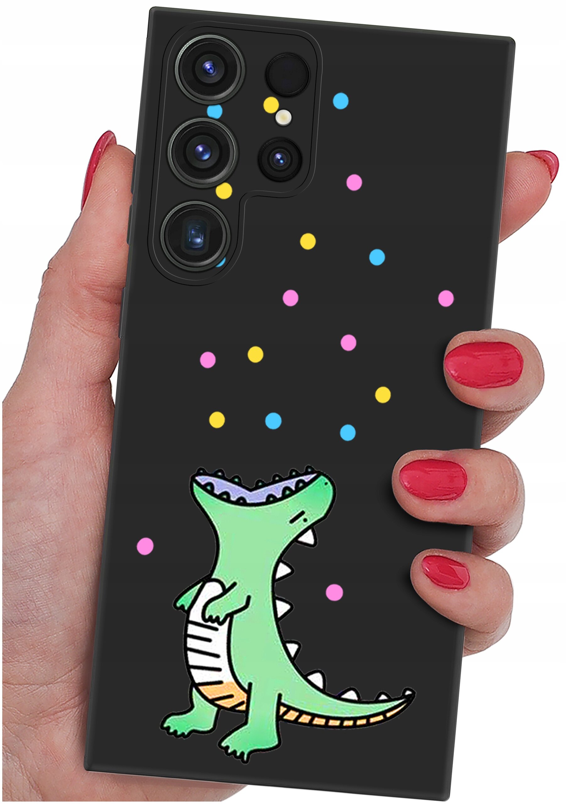 Czarna obudowa telefonu z kolorowym wzorem przedstawiającym zielonego dinozaura i kolorowe kropki. Obudowa jest trzymana w dłoni z pomalowanymi na czerwono paznokciami.