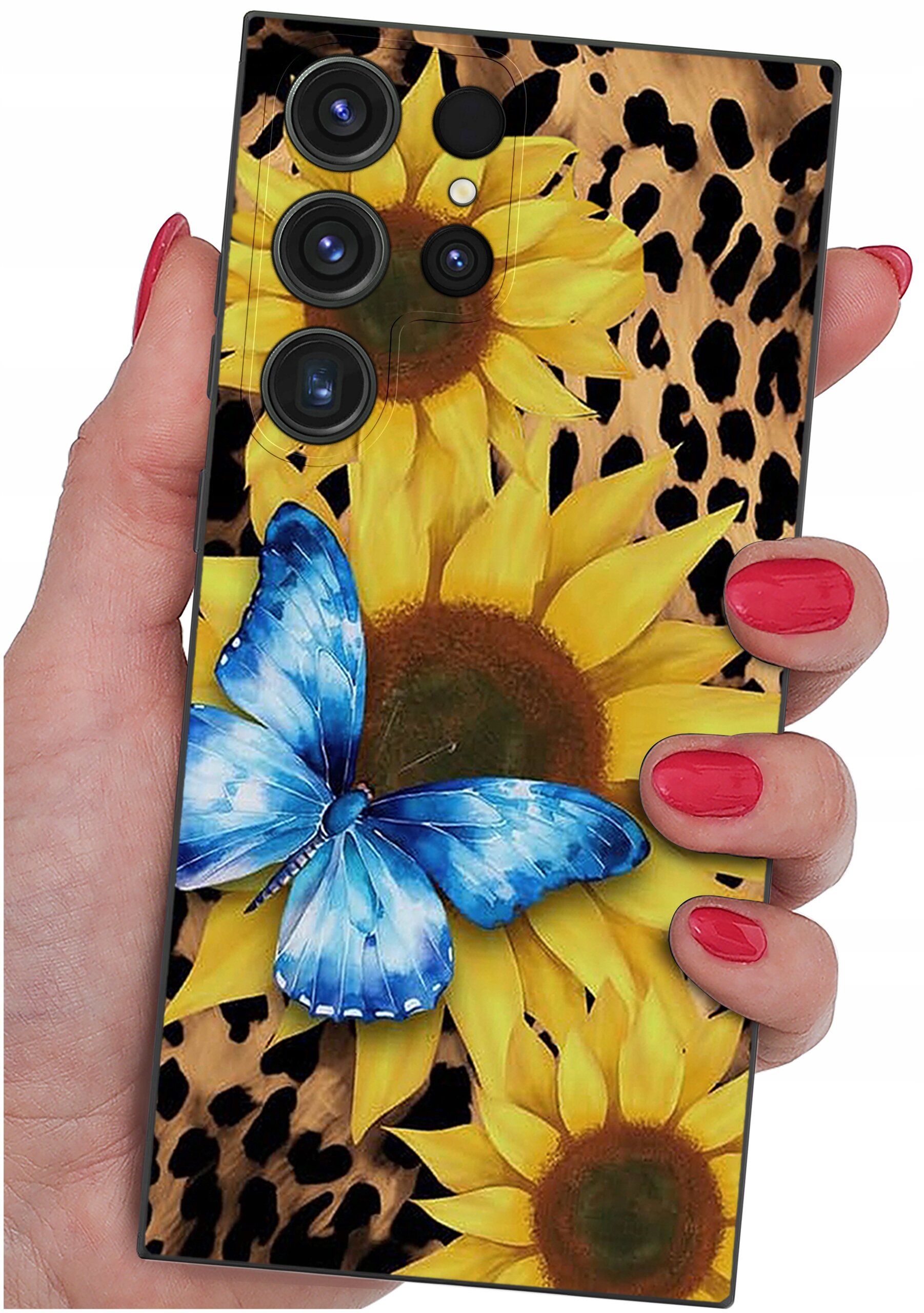 Etui na telefon z wzorem słoneczników i niebieskiego motyla na tle przypominającym skórę lamparta. Etui trzymane jest w dłoni z pomalowanymi na czerwono paznokciami.