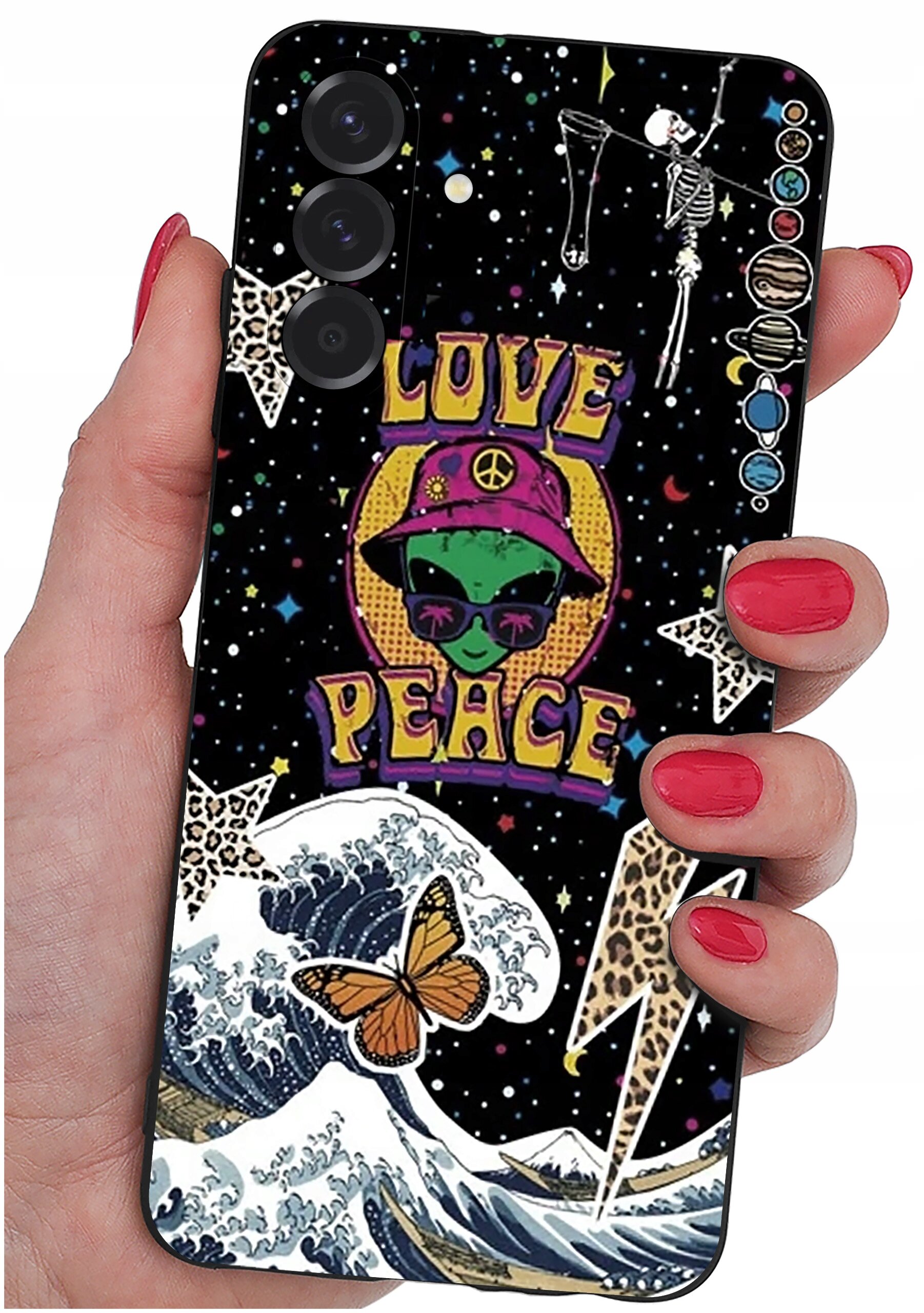 Etui na telefon z kolorowym wzorem przedstawiającym zieloną postać w kapeluszu, napis \'LOVE PEACE\', fale, motyla i szkielety na tle gwiazd. Etui trzymane jest w dłoni z pomalowanymi na czerwono paznokciami.