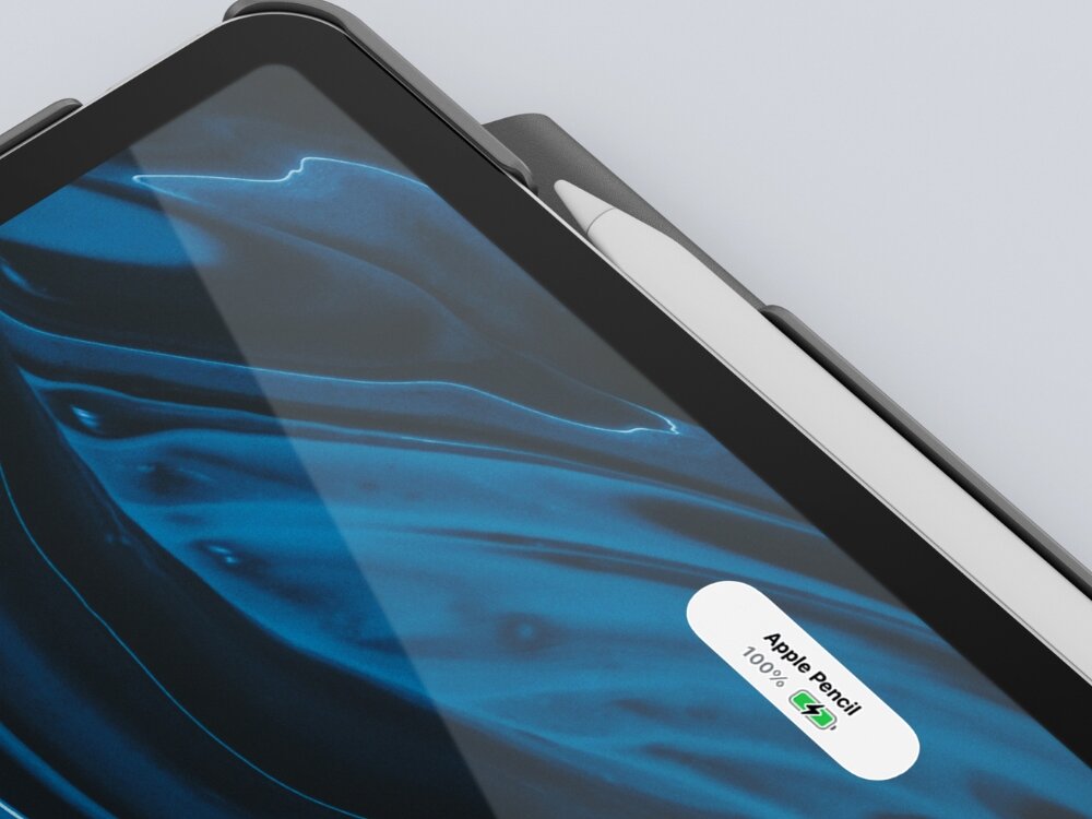 Na obrazie widoczny jest fragment tabletu z niebieskim wzorem na ekranie oraz białym rysikiem umieszczonym w etui. Na ekranie wyświetla się tekst: \'Apple Pencil 100%\'.