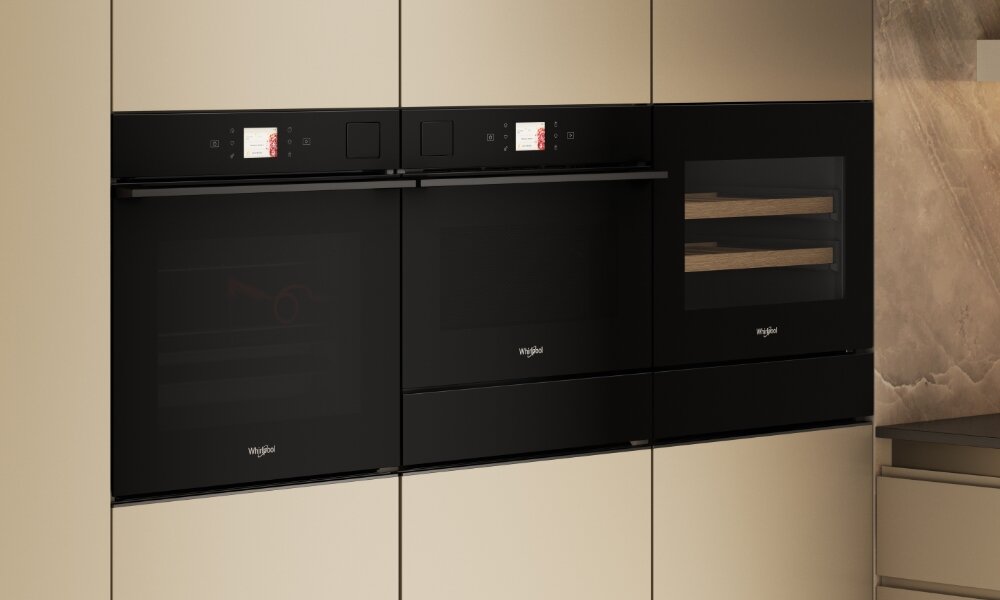 Trzy czarne piekarniki w zabudowie z wyświetlaczami i logo \'whirlpool\'.