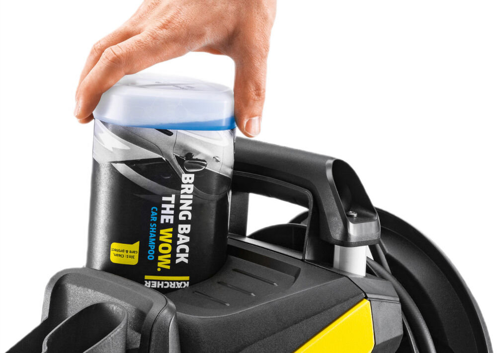 Ręka trzyma pojemnik z napisem \'BRING BACK THE WOW CAR SHAMPOO\' umieszczony na urządzeniu z logo KARCHER.