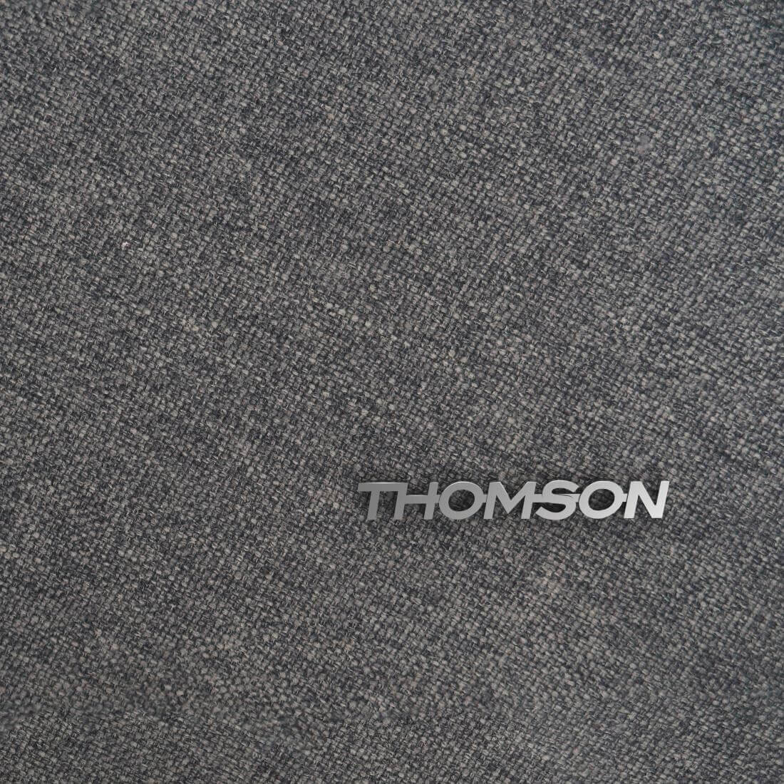 Szara, teksturowana powierzchnia z widocznym logo \'THOMSON\'.