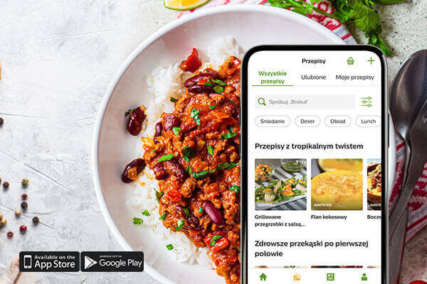 Na obrazie widoczny jest talerz z daniem z ryżem i mięsem w sosie, obok znajduje się smartfon z aplikacją kulinarną wyświetlającą przepisy. Na dole ekranu widoczne są ikony sklepów App Store i Google Play.