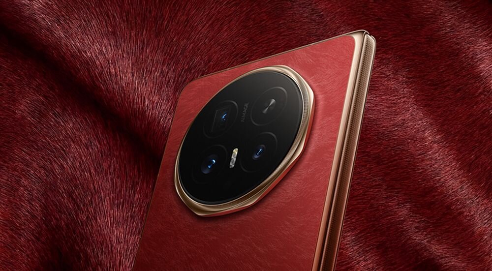 Smartfon z widocznym modułem aparatu z trzema obiektywami i lampą błyskową, umieszczony na tle materiału o teksturze przypominającej futro w kolorze bordowym.