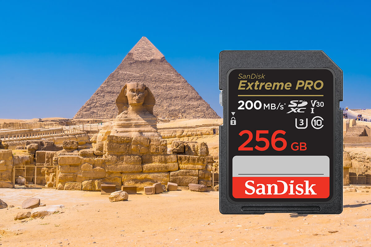 Na obrazie widoczna jest karta pamięci z napisem \'SanDisk Extreme PRO 200 MB/s SDXC I V30 256 GB\'. W tle znajduje się Sfinks i piramida na pustynnym terenie.