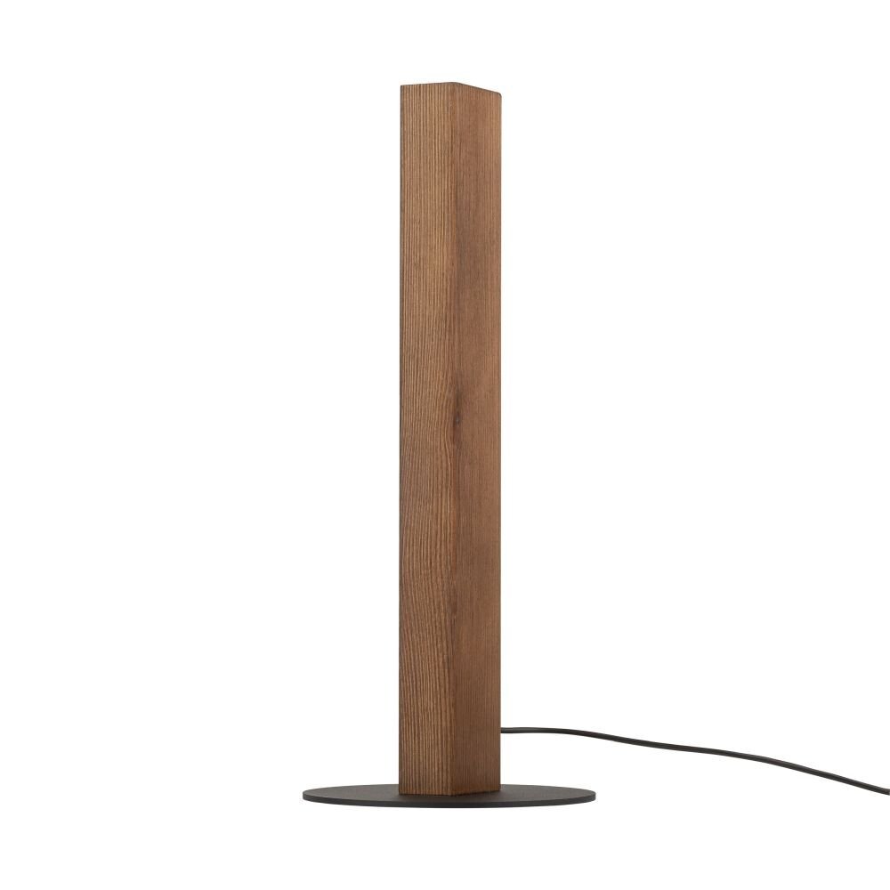 Lampa stołowa o prostokątnym, drewnianym korpusie w kolorze orzecha, umieszczona na okrągłej, czarnej podstawie. Z lampy wychodzi czarny przewód zasilający.