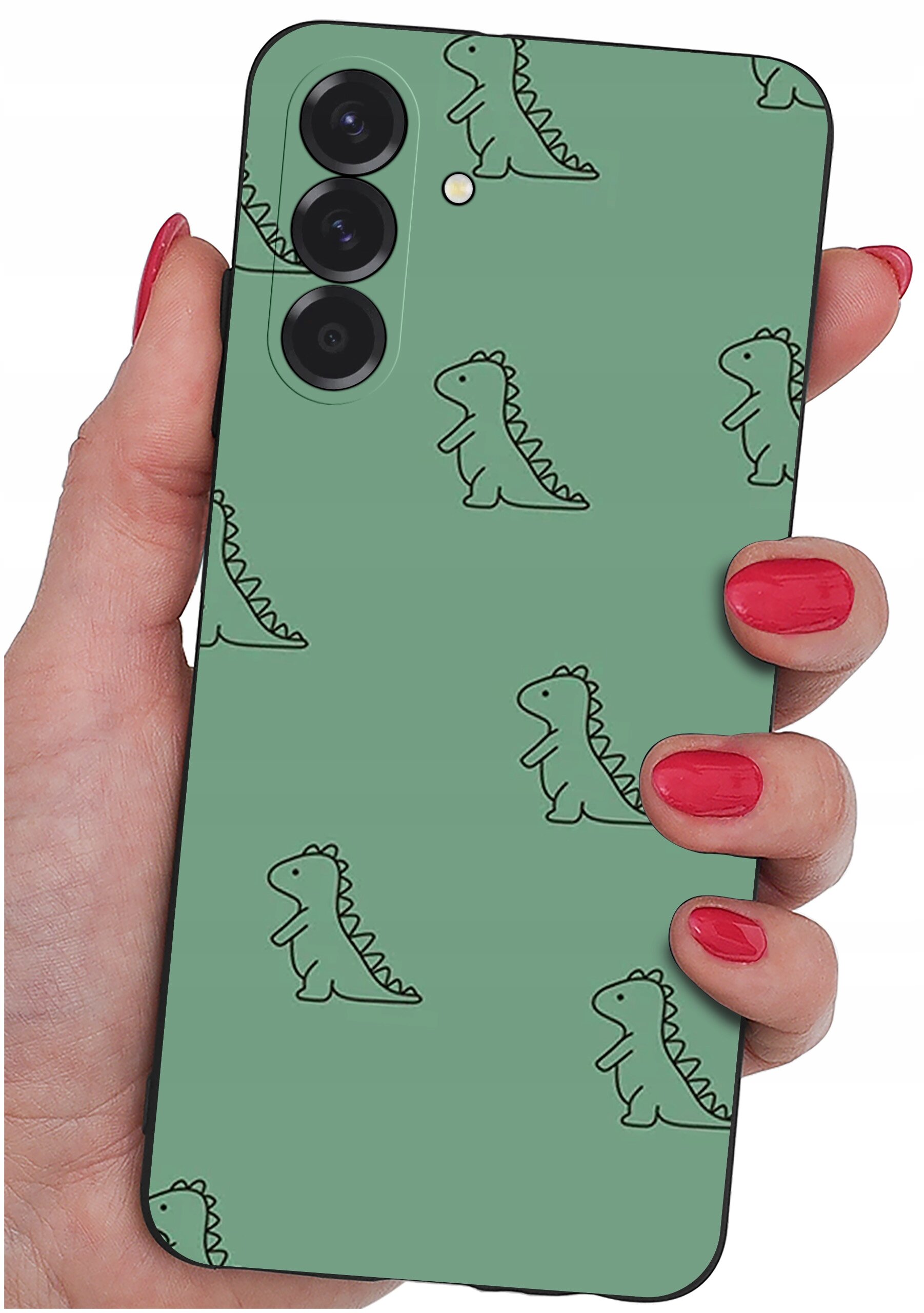 Etui na telefon w kolorze zielonym z wzorem małych dinozaurów, trzymane w dłoni z pomalowanymi na czerwono paznokciami. Etui posiada wycięcia na trzy obiektywy aparatu.