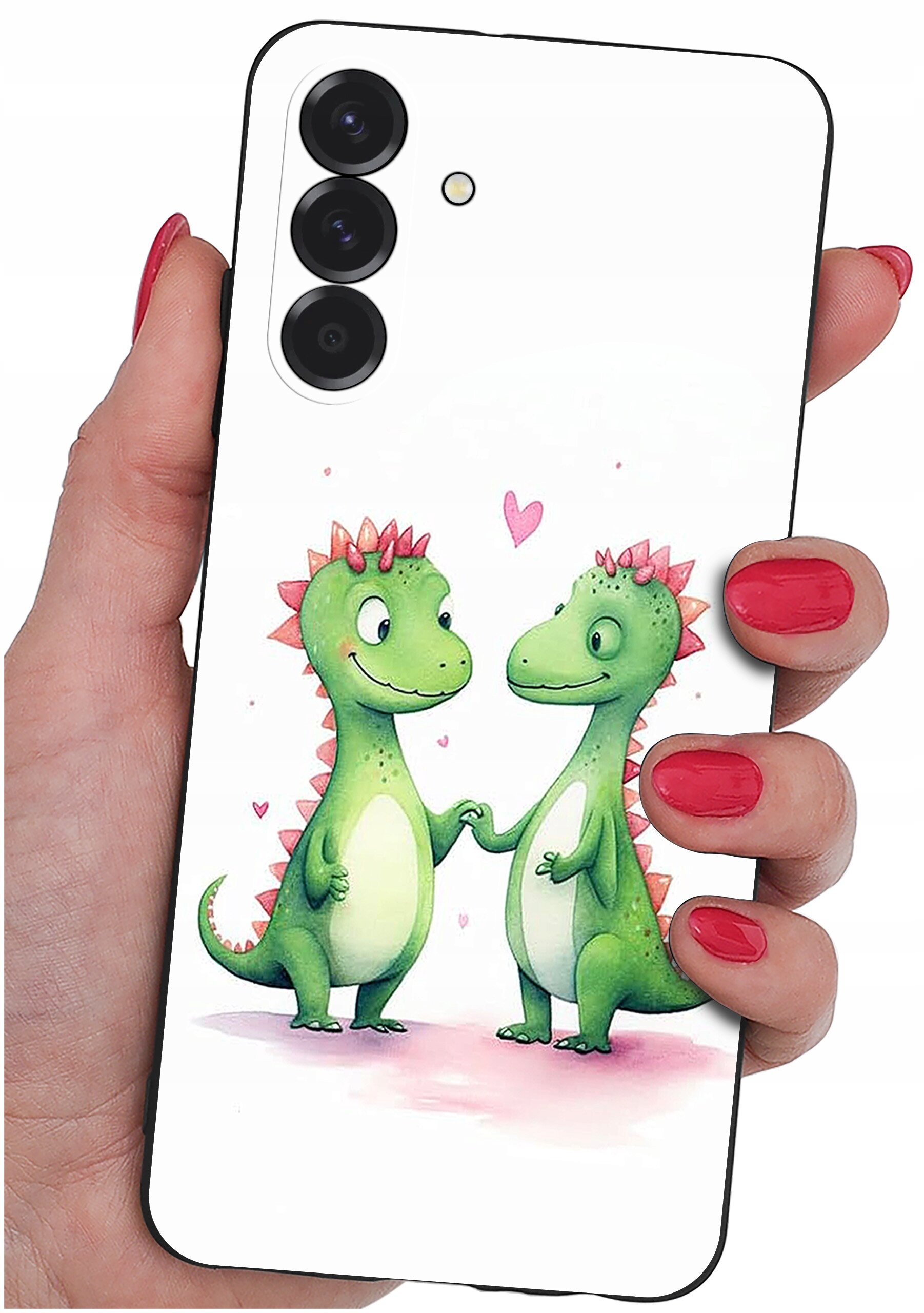 Etui na telefon z grafiką dwóch zielonych dinozaurów trzymających się za ręce, otoczonych różowymi serduszkami. Etui jest trzymane w dłoni z pomalowanymi na czerwono paznokciami.