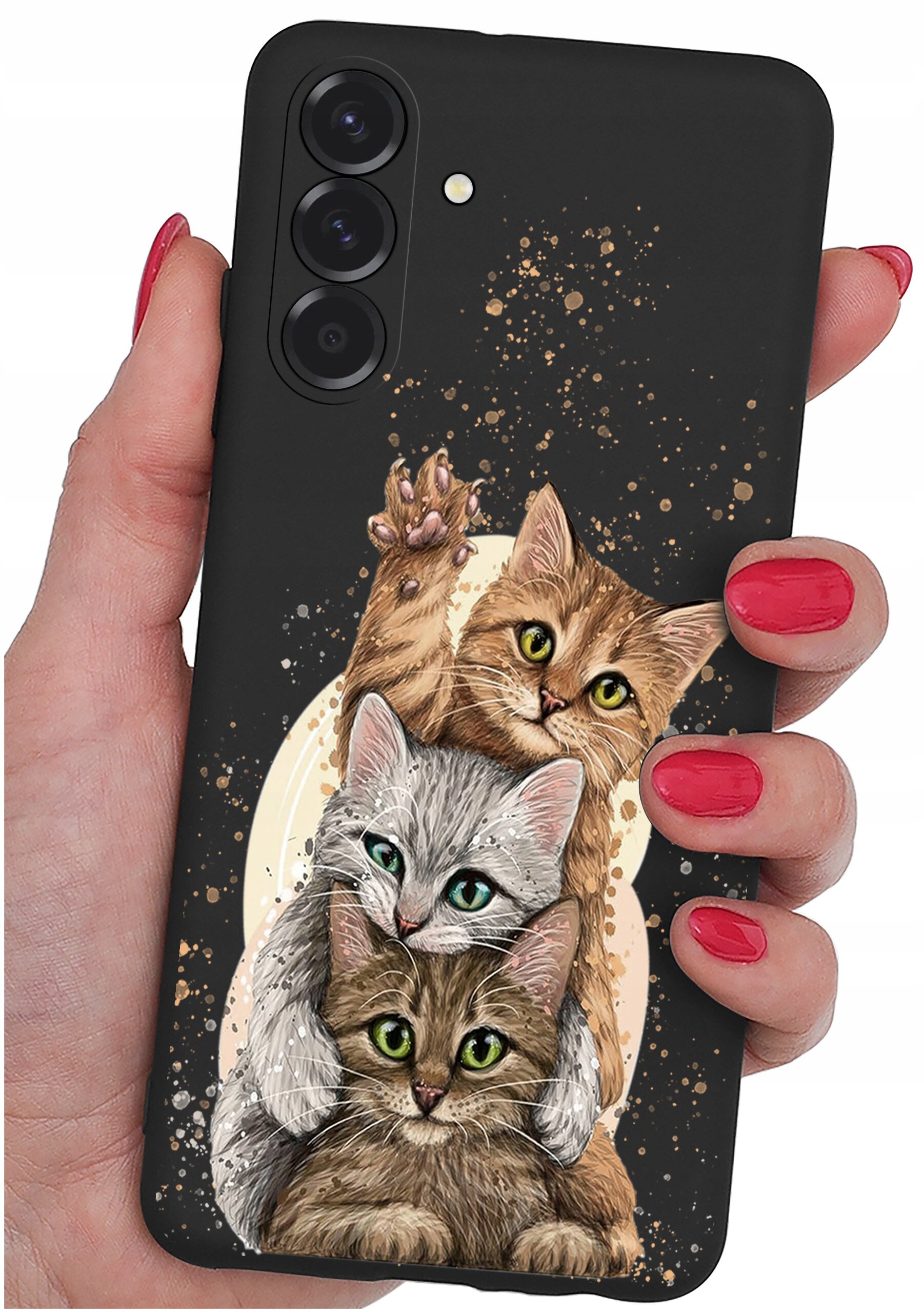 Czarne etui na telefon z trzema rysunkowymi kotami, trzymane w dłoni z czerwonymi paznokciami. Etui ma wycięcia na trzy obiektywy aparatu i lampę błyskową.