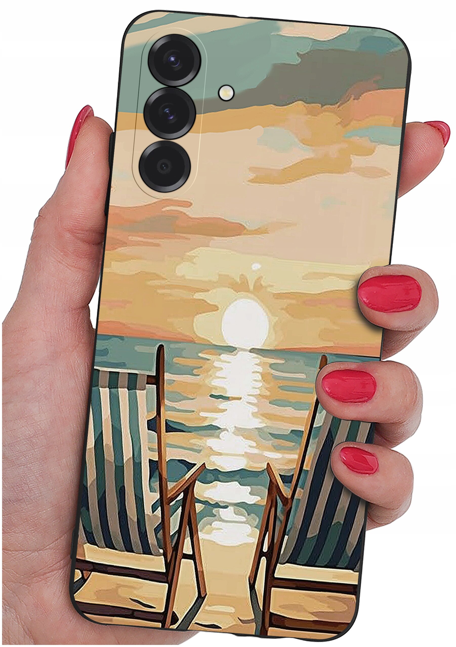 Etui na telefon z wzorem przedstawiającym zachód słońca nad morzem z dwoma leżakami na plaży. Etui trzymane jest w dłoni z pomalowanymi na czerwono paznokciami.