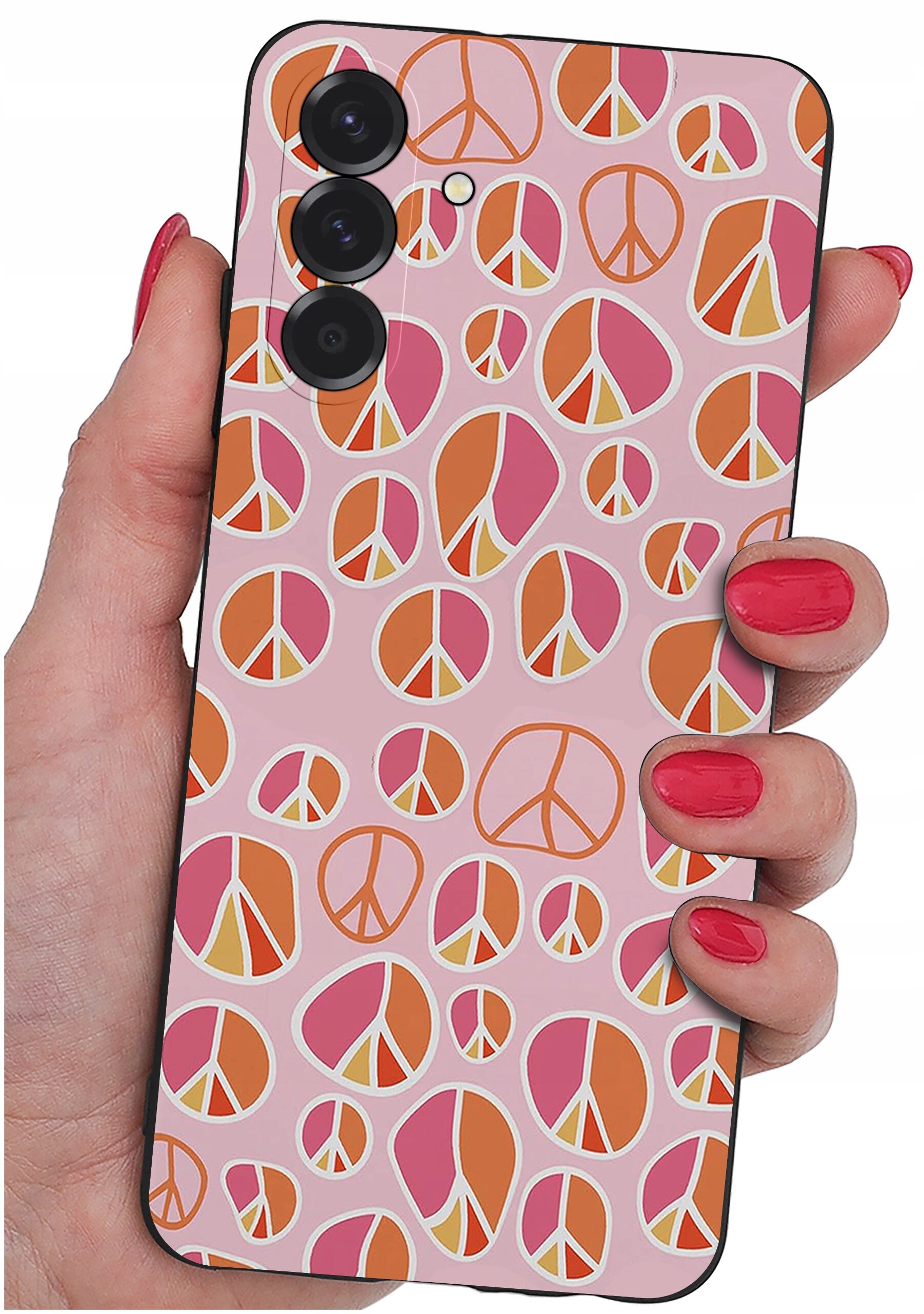 Etui na telefon z wzorem w kolorowe symbole pokoju, trzymane w dłoni z pomalowanymi na czerwono paznokciami. Etui ma różowe tło z pomarańczowymi i różowymi elementami.