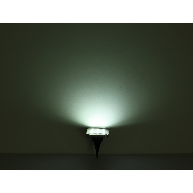Na obrazie widoczna jest lampa solarna emitująca jasne, rozproszone światło na ciemnym tle. Lampa ma stożkowy kształt podstawy i jest zamontowana na powierzchni.
