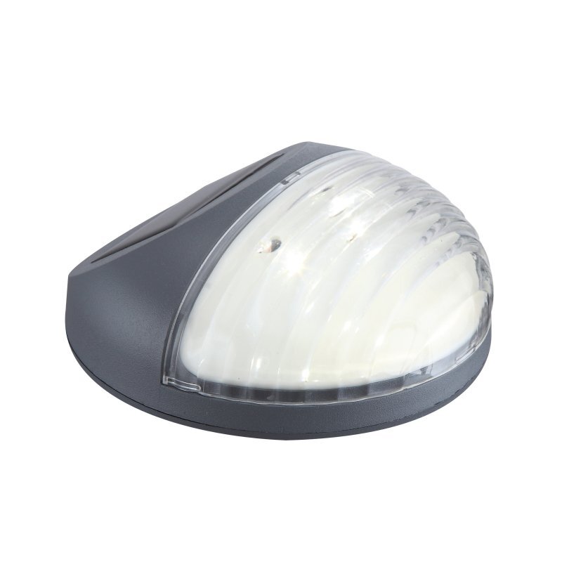 Na obrazie widoczna jest lampa solarna LED o półokrągłym kształcie, z przezroczystą osłoną i ciemnoszarą obudową. Lampa przeznaczona jest do montażu na ogrodzeniu.